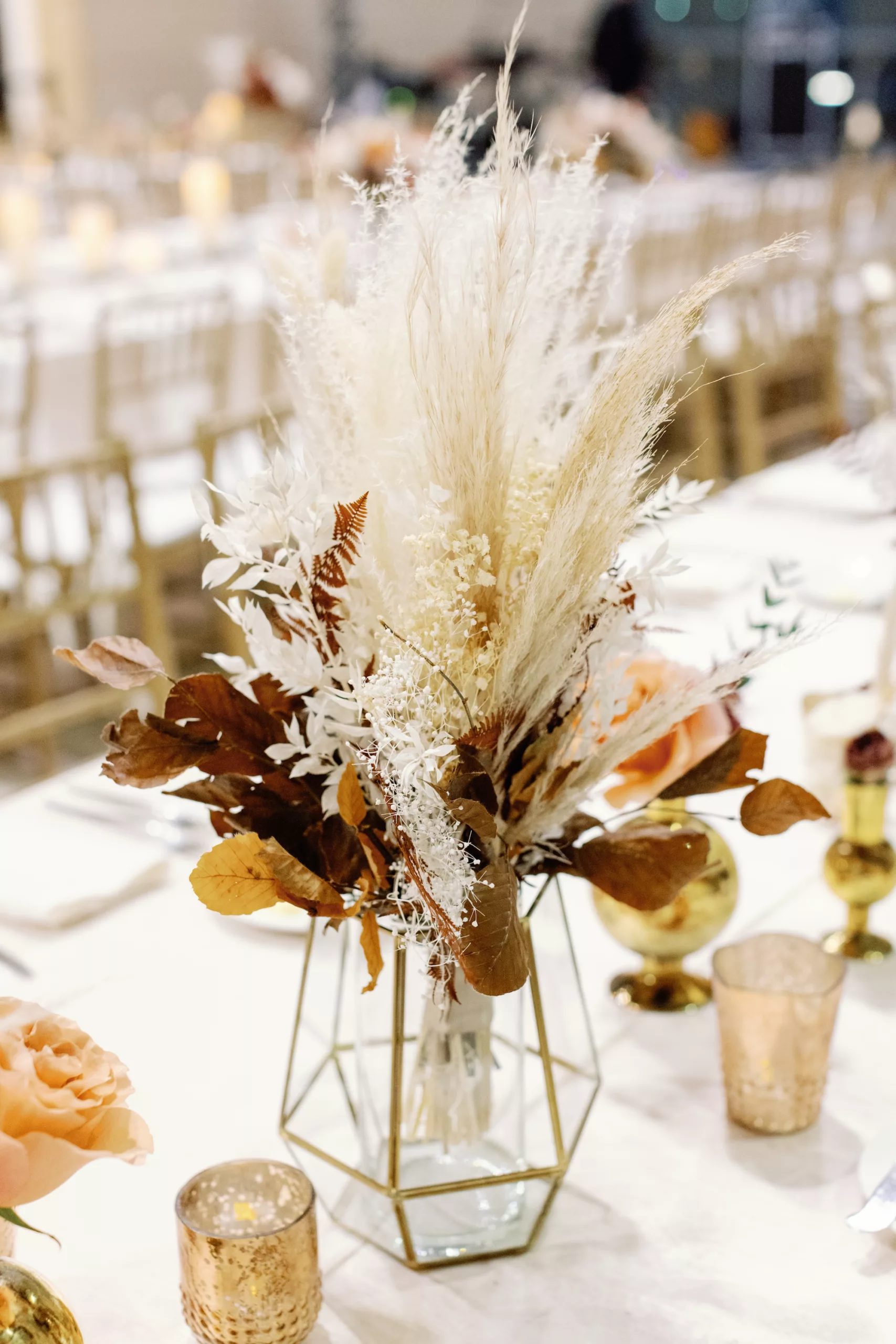 White and Burnt Orange Boho Indian Wedding Reception Centerpiece Decor Ideas | Dried Pampas Grass, Ferns, Brown Leaves and Gold Geometric Vase