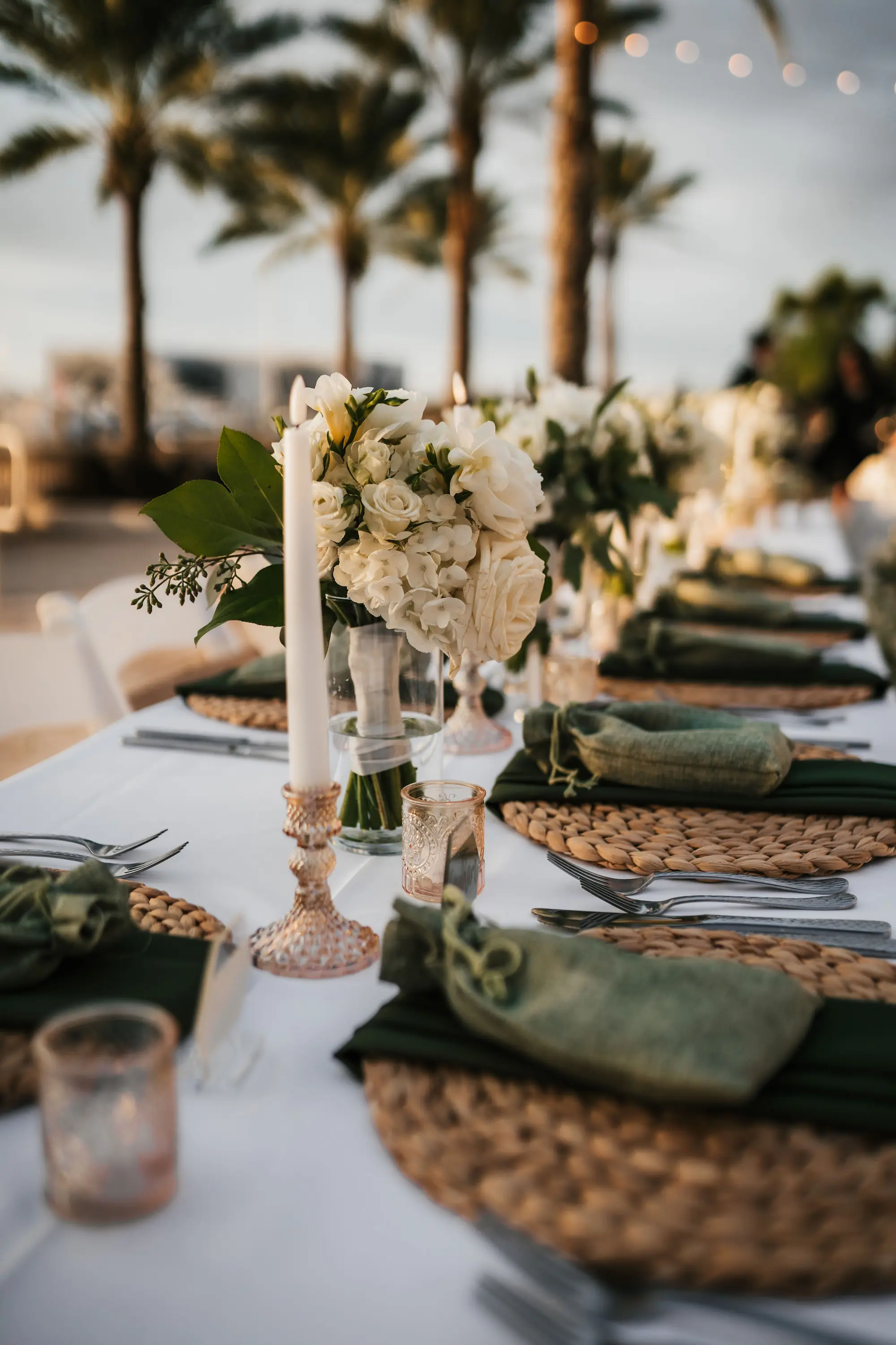 Timeless Outdoor Wedding Reception Place Setting Decor Inspiration | Flameless Candles, White Roses, and Hydrangeas Centerpiece Ideas | Hyacinth Placemat, Black Linen Napkins, and Green Guest Gift Ideas