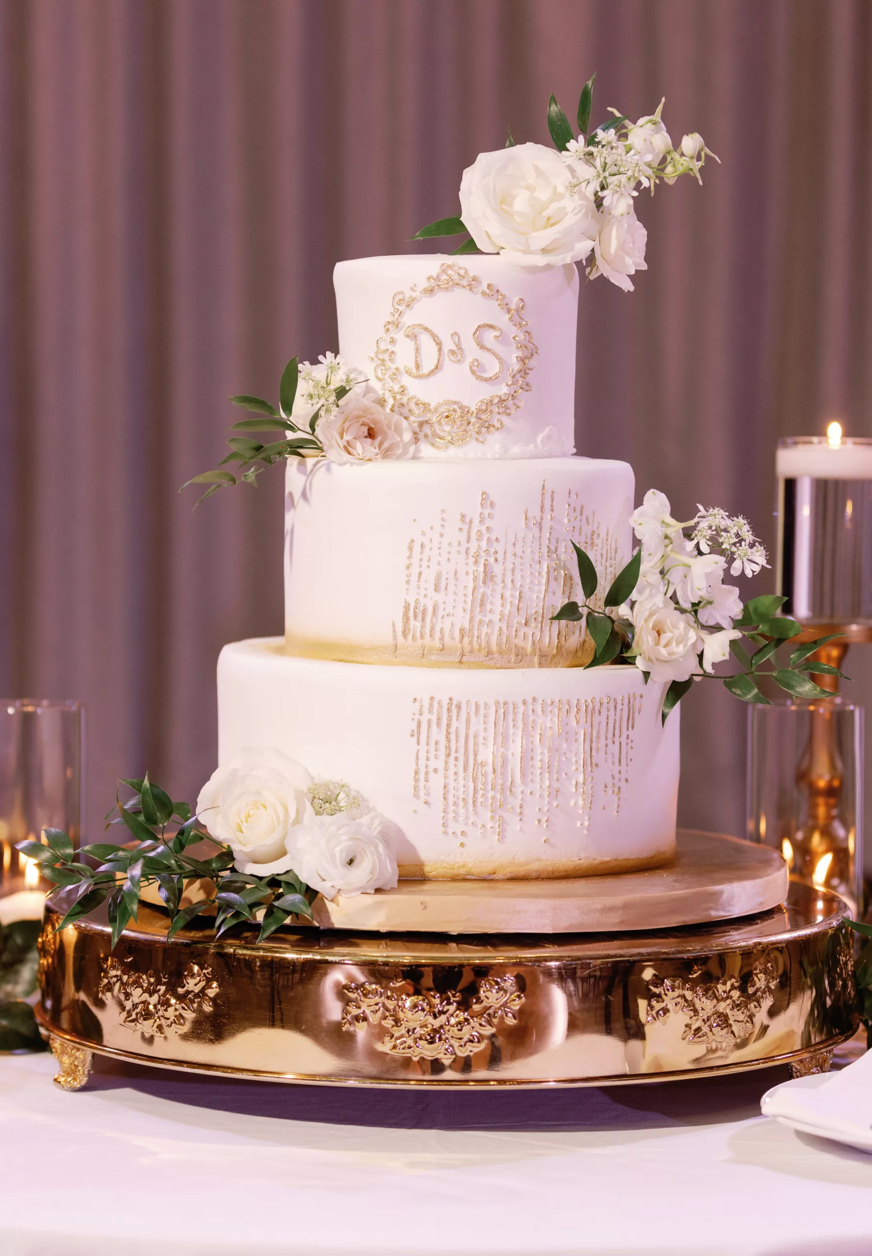 Round Three-Tiered White and Gold Fondant Wedding Cake with White Roses, and Greenery Accent Inspiration