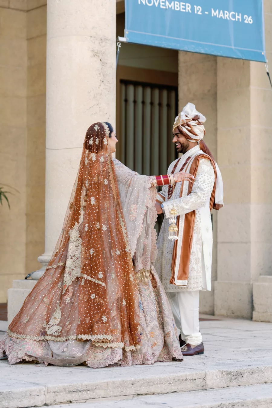Bride and Groom First Look Wedding Portrait | Neutral Burnt Orange and Cream Beaded Rimple and Harpreet Lehenga Indian Wedding Dress Inspiration | White and Brown Groom's Sherwani Wedding Attire Ideas