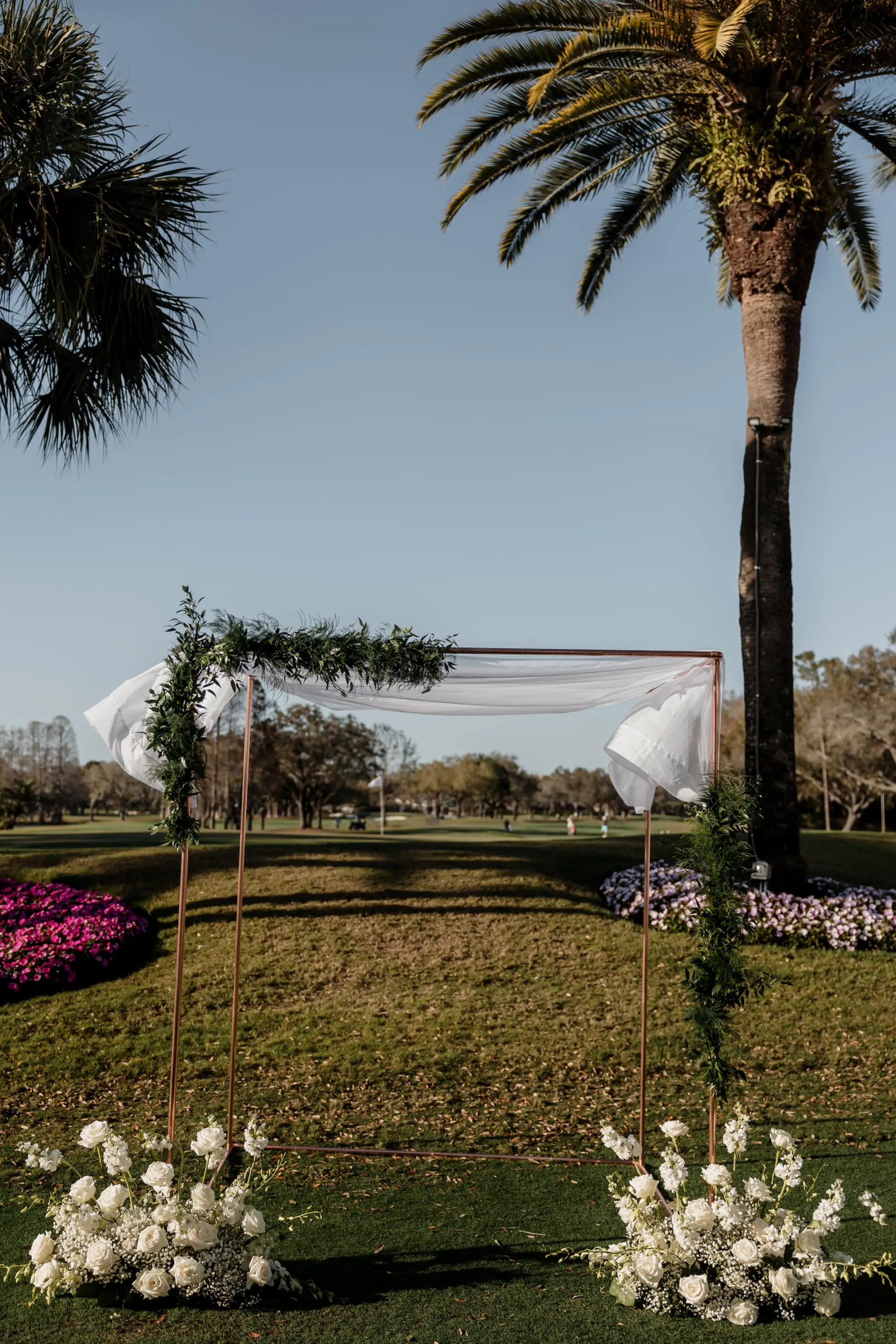 Outdoor Golf Course Wedding Ceremony Decor Ideas | Classic Gold Arbor with White Monochromatic Roses and Baby's Breath Flower Arrangement Inspiration