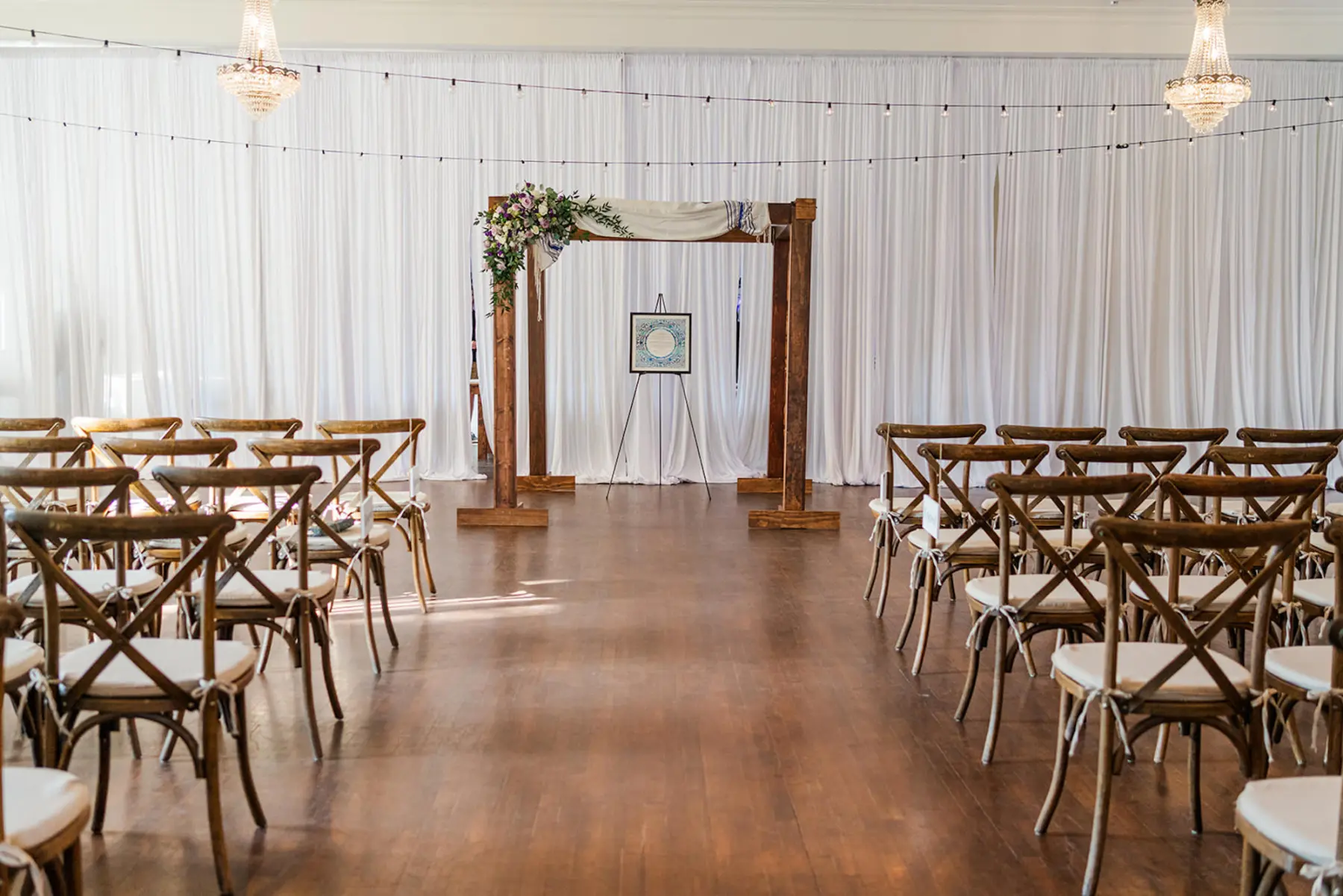 Elegant Wooden Wedding Jewish Ceremony Chuppah Arch with Purple Spring Floral Inspiration with White Drapping and Crossaback Chairs | Tampa Venue The Orlo