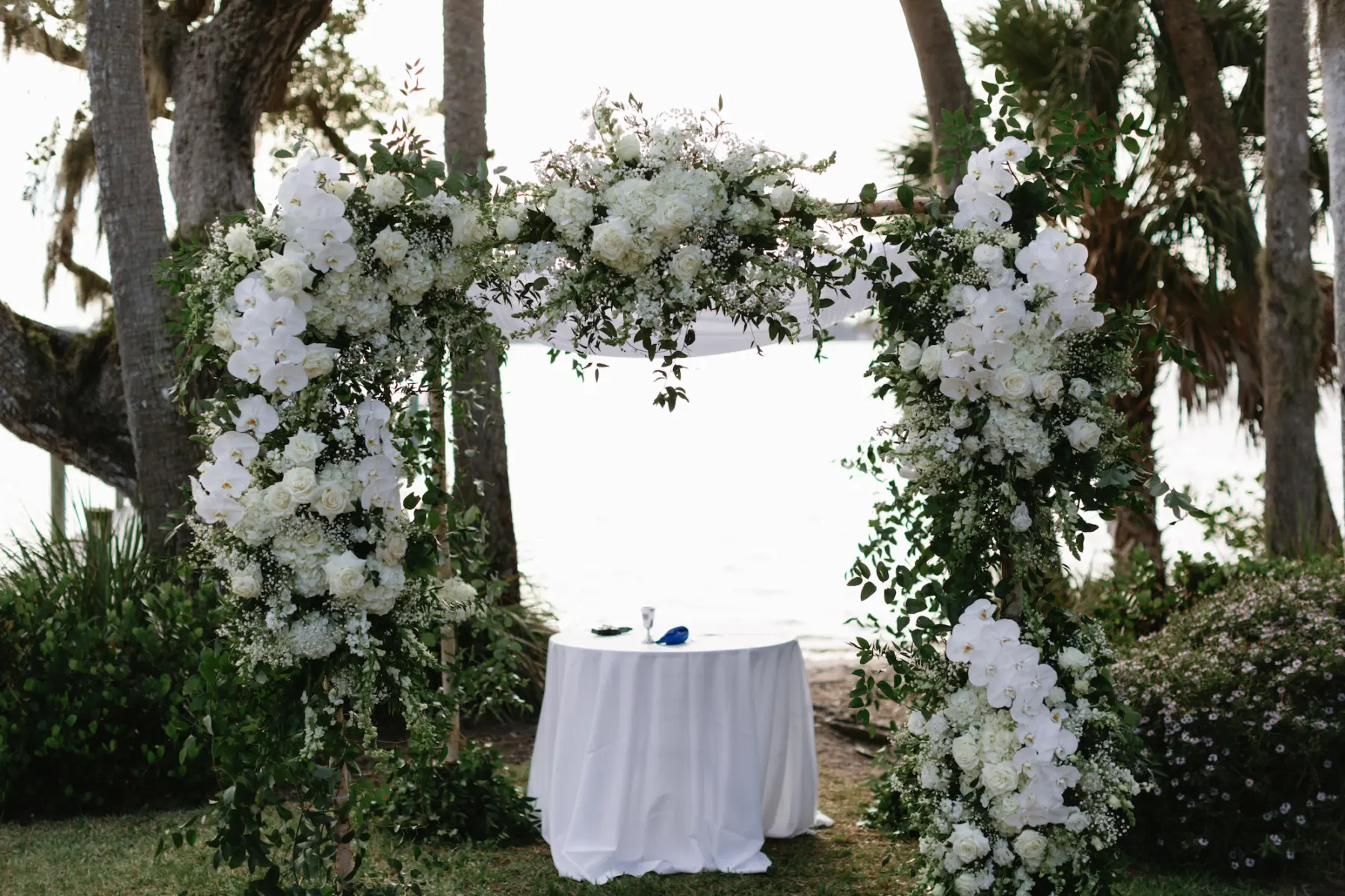 Classic White Wedding Ceremony Arch with White Roses, Orchids, Baby's Breath, Hydrangeas, and Greenery Decor Inspiration | Tampa Bay Florist Beneva Florals