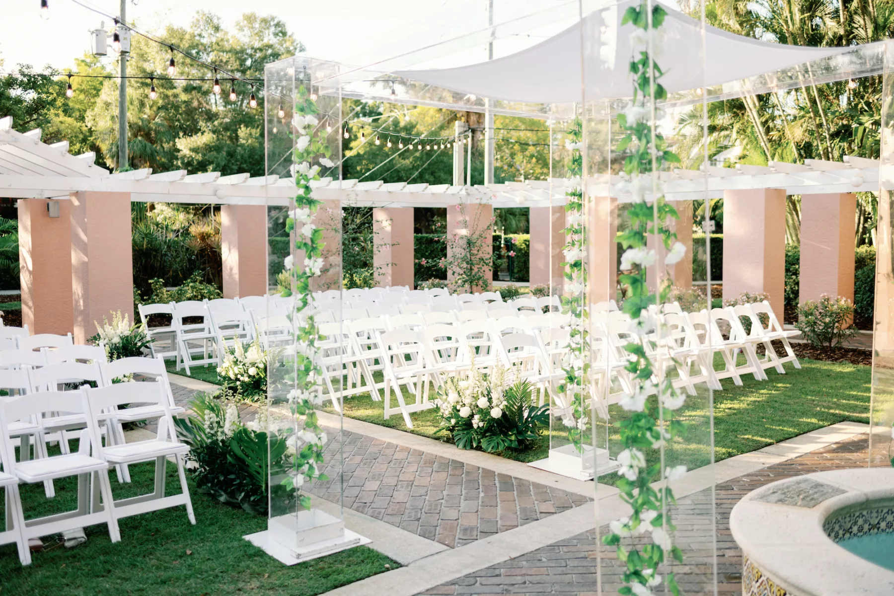 Timeless Outdoor Jewish Tea Garden Wedding Ceremony Decor Inspiration | White Folding Garden Chairs | Acrylic Chuppah with White Roses and Greenery Garland | St Pete Photographer Dewitt For Love | Event Planner Coastal Coordinating | Florist Botanica Design Studio | St. Pete Venue The Vinoy