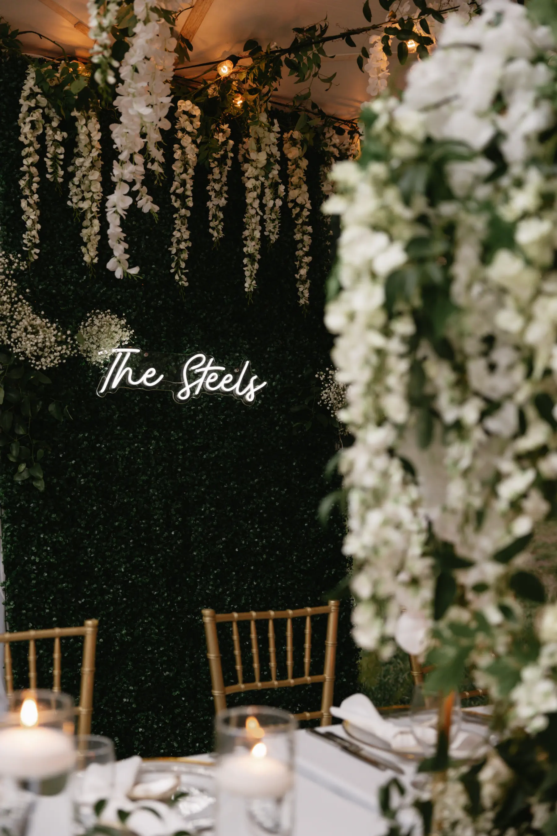 Classic Wedding Reception Sweetheart Table Decor Inspiration | Greenery Backdrop with White Cascading Wisteria with Neon Sign | Tampa Bay Florist Beneva Florals