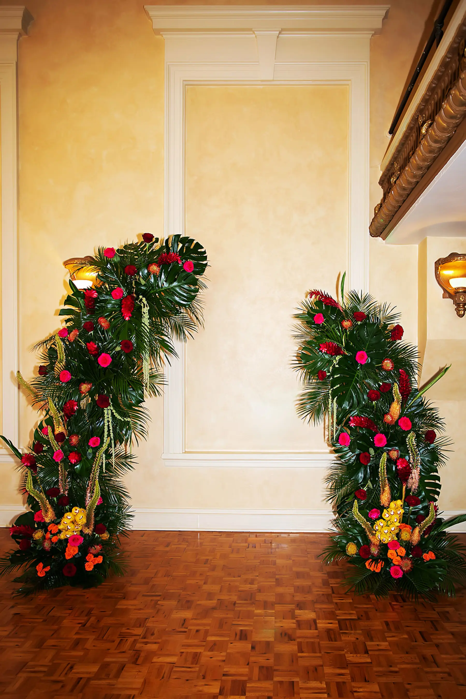 Asymmetrical Tropical Wedding Ceremony Floral Arch with Red and Pink Roses, Yellow Wisteria, Monstera, Palm Leaf Decor Inspiration