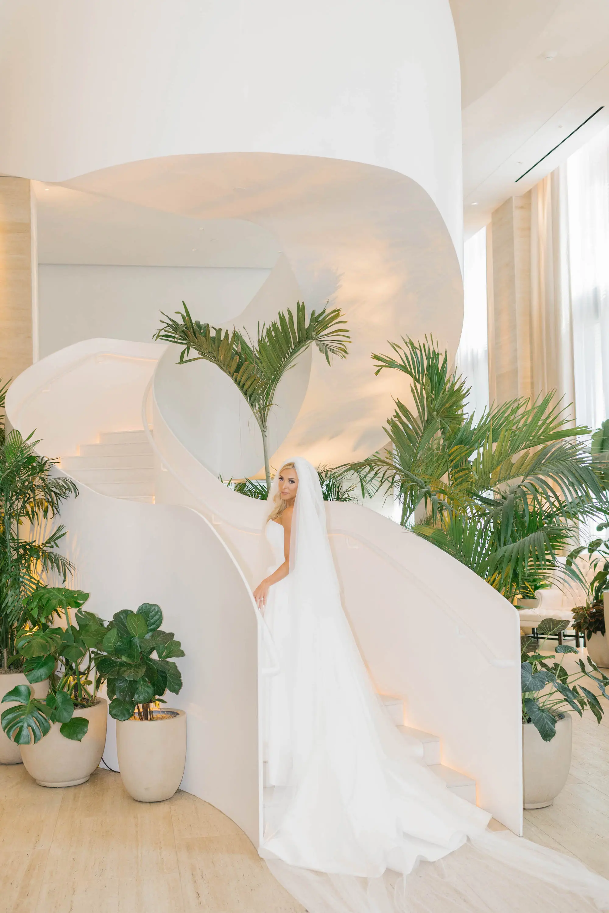 Strapless White Modern Isabel O’Neil Bridal Rivini Collection Designer Rita Vinieris Wedding Dress with Cathedral Length Train and Veil | Downtown Event Venue The Edition Hotel Tampa Water Street Lobby Staircase | Bridal Portrait Inspiration | Planner Coastal Coordinating
