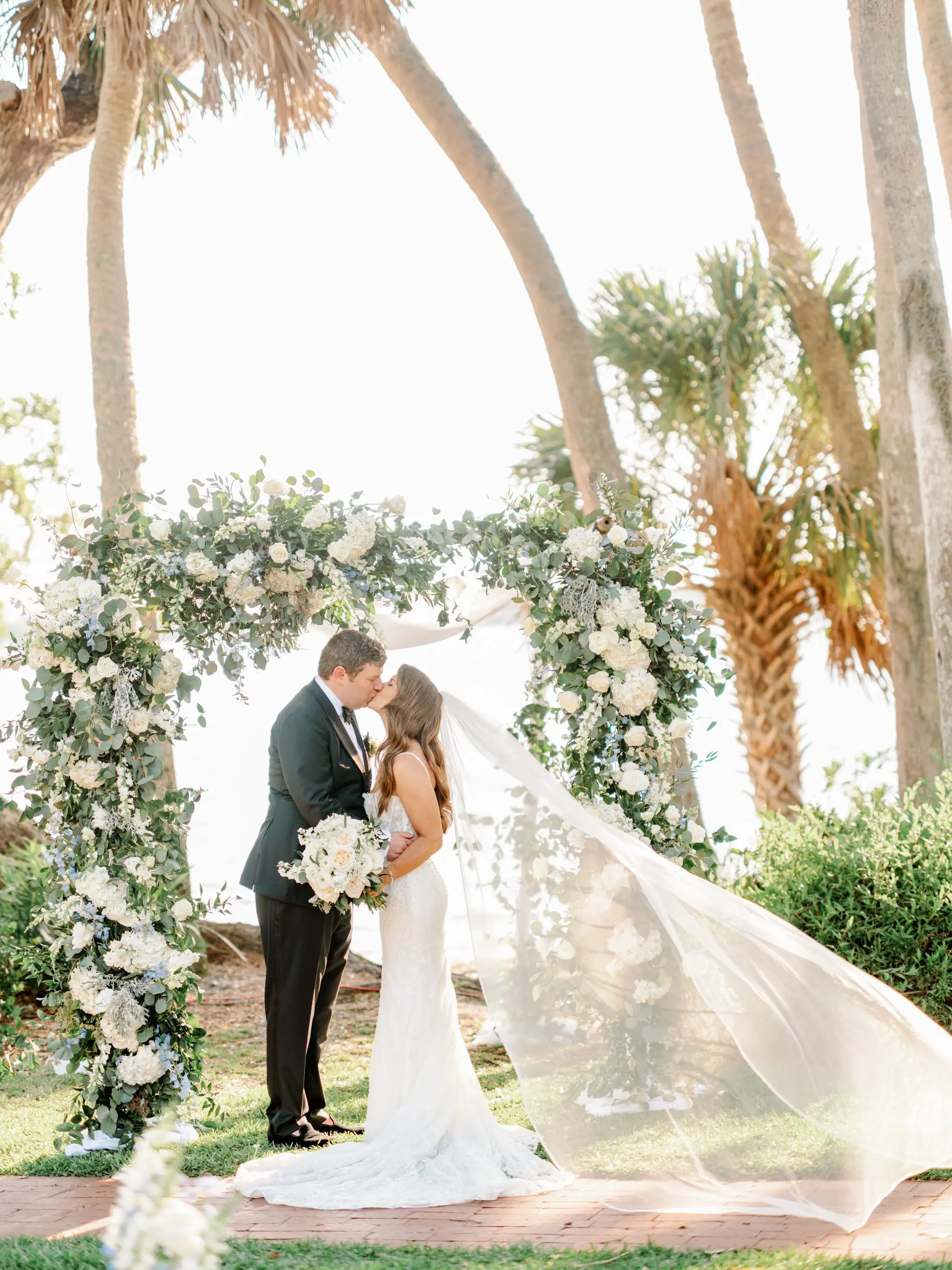 Bride and Groom Just Married Wedding Portrait | Luxurious White and Blue Flowers, and Greenery Wedding Ceremony Arch Decor Inspiration | Tampa Bay Florist Beneva Flowers