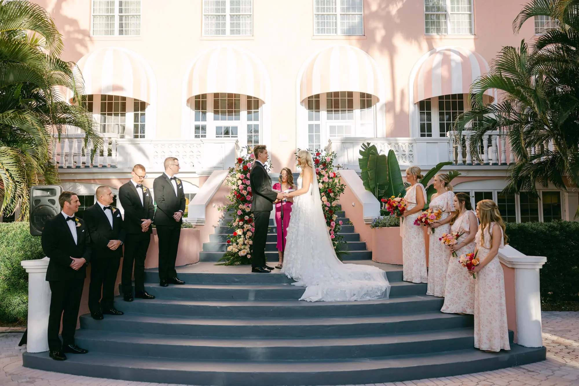 Bride and Groom Wedding Ceremony Vow Exchange Wedding | Vibrant Whimsical St Pete Beach Old Florida Wedding Ceremony Decor Inspiration | Pink, Red, Peach, Orange Floral Arrangement Wedding Ceremony Altar Decor Ideas | St Pete Event Venue The Don Cesar