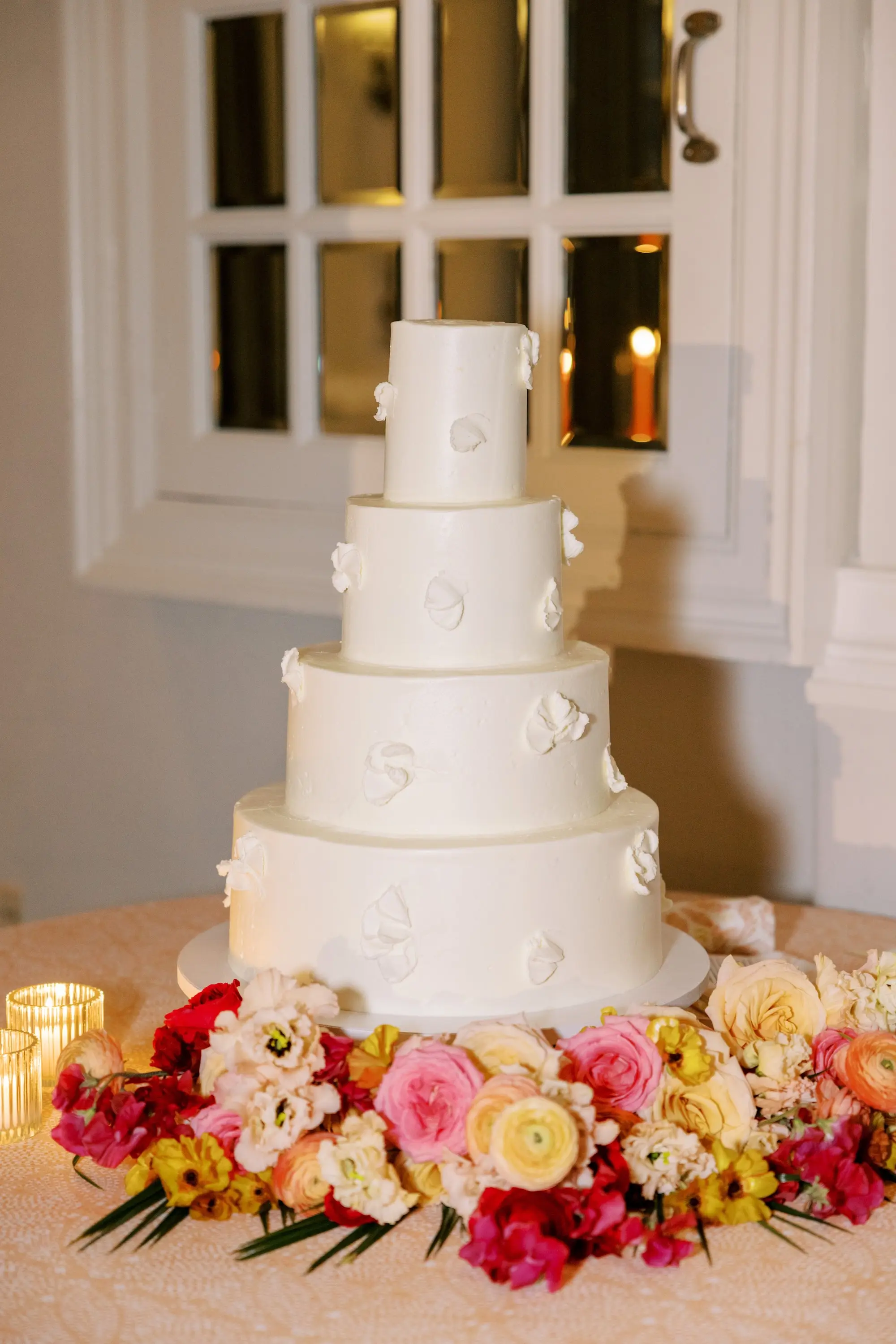 Simple Modern Monochromatic White Four-Tiered Wedding Cake Inspiration | Tropical Pink, Yellow, Red, Orange Florals with Green Palms Table Decor Ideas
