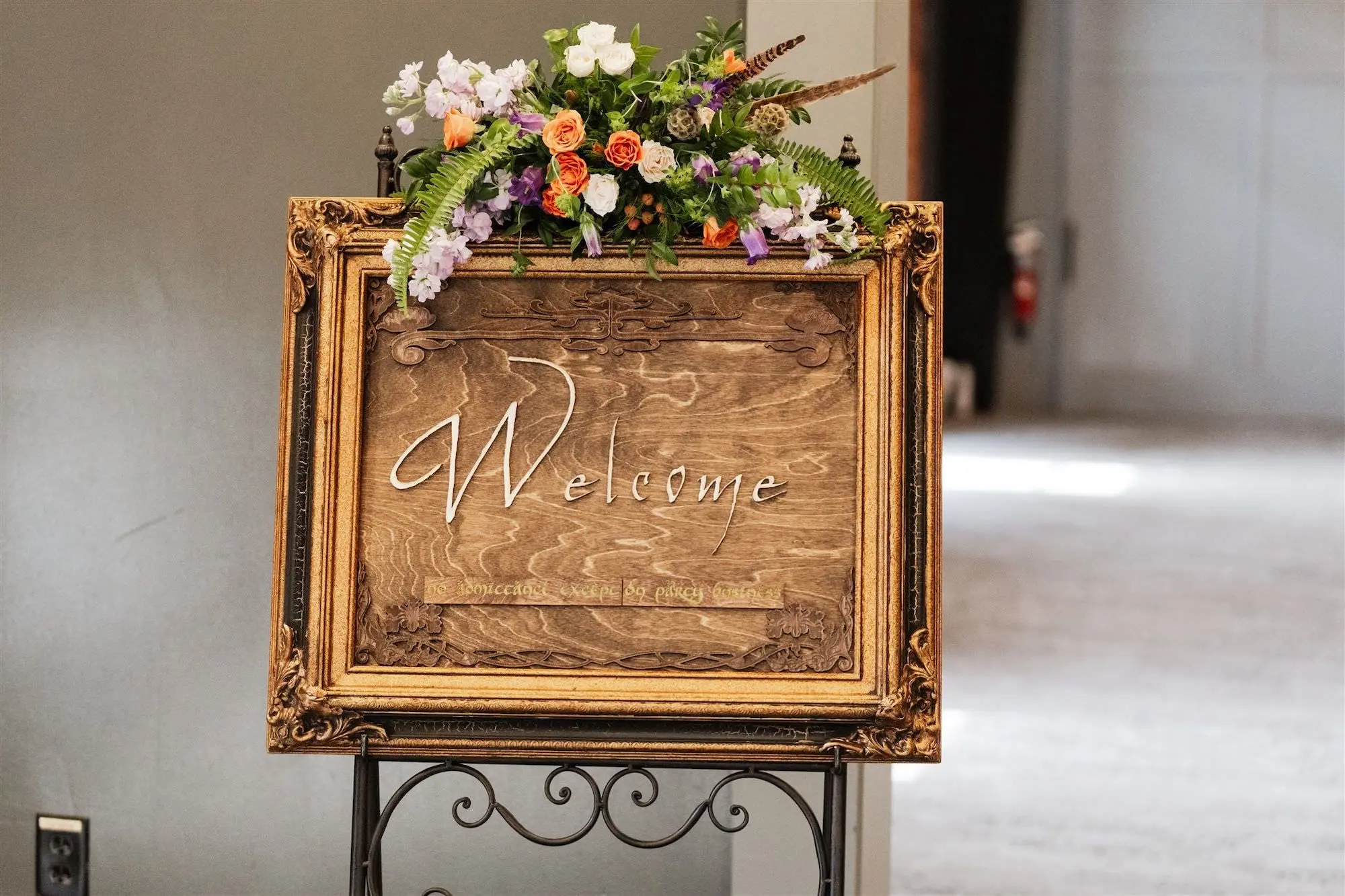 Whimsical Lord of the Rings Inspired Rustic Wooden Welcome Wedding Sign Decor Ideas | Elegant Fantasy Floral Arrangement with White and Purple Freesia, Orange and Light Pink Roses with Green Ferns Inspiration | Lord of the Rings Wedding Reception Ceremony Theme Ideas