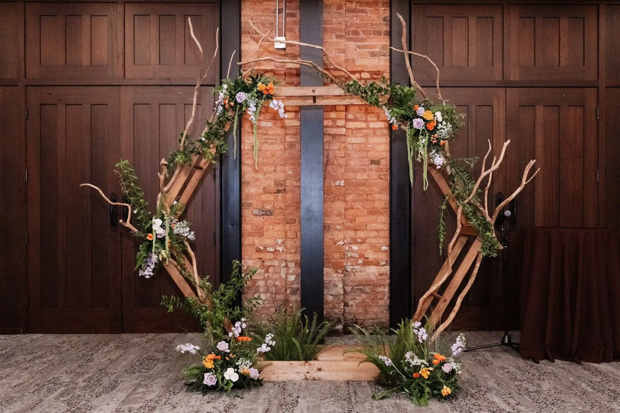Whimsical Lord of the Rings Wedding Reception Altar Arch Decor Inspiration | Rustic Wooden Branches Hexagon Altar Arch Wedding Ceremony Ideas | Floral Arrangements Decor White, Prink, Orange, Purple Flowers and Fern and Moss Greenery Inspiration | Exposed Brick and Wooden Panels Wedding Tampa Bay Venue Ideas | Planner UNIQUE Weddings and Events