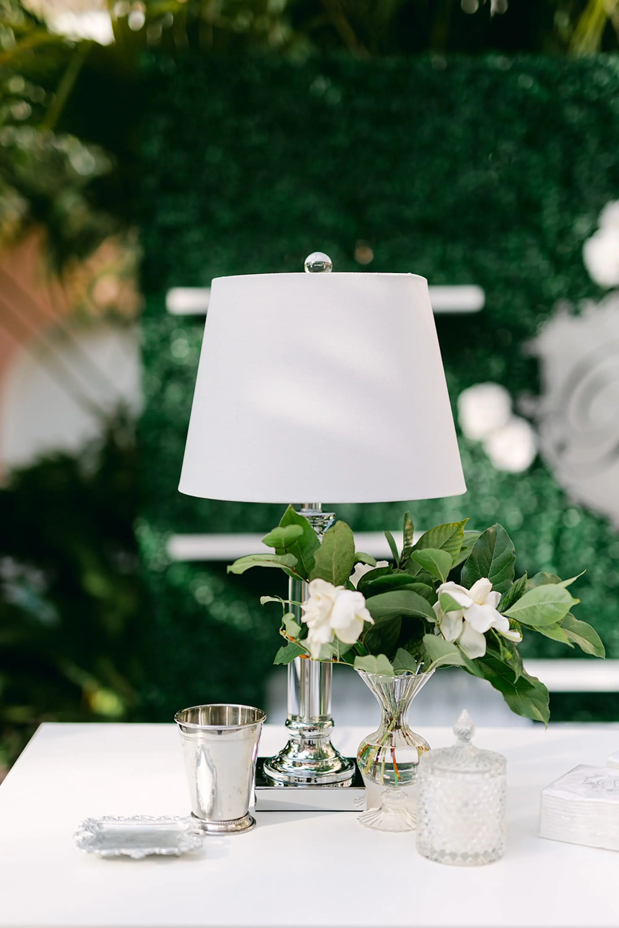 Luxurious Ivory and Gold Wedding Reception Table Decor Inspiration | Silver Miniature Table Lamp Outdoor Cocktail Hour Tablescape Decor Ideas | Bud Vases with Simple White Florals and Greenery Centerpiece Decor Inspiration