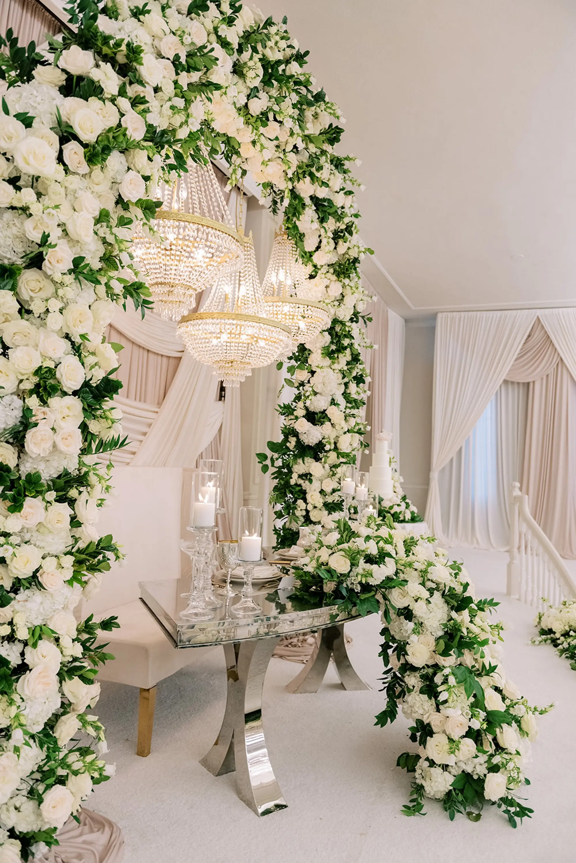 Glamorous Ivory and Gold Wedding Reception Sweetheart Table Decor Ideas | Crystal Chandelier and Romantic Candlelight Reception Table Decor Inspiration | Classic, Luxurious White Roses and Flowers in Lush Greenery Arch Floral Decor Centerpieces Ideas | St Pete Event Planner Parties A La Carte