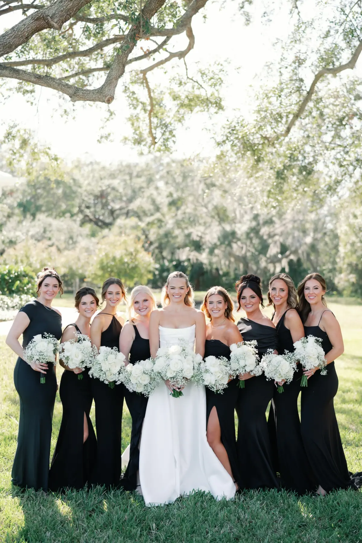 Bride and Bridesmaids Wedding Portrait | Mismatched Black Bridesmaid Dresses Inspiration | Timeless White Roses and Baby's Breath Bouquet Ideas | Sarasota Hair and Makeup Artist Femme Akoi Beauty Studio