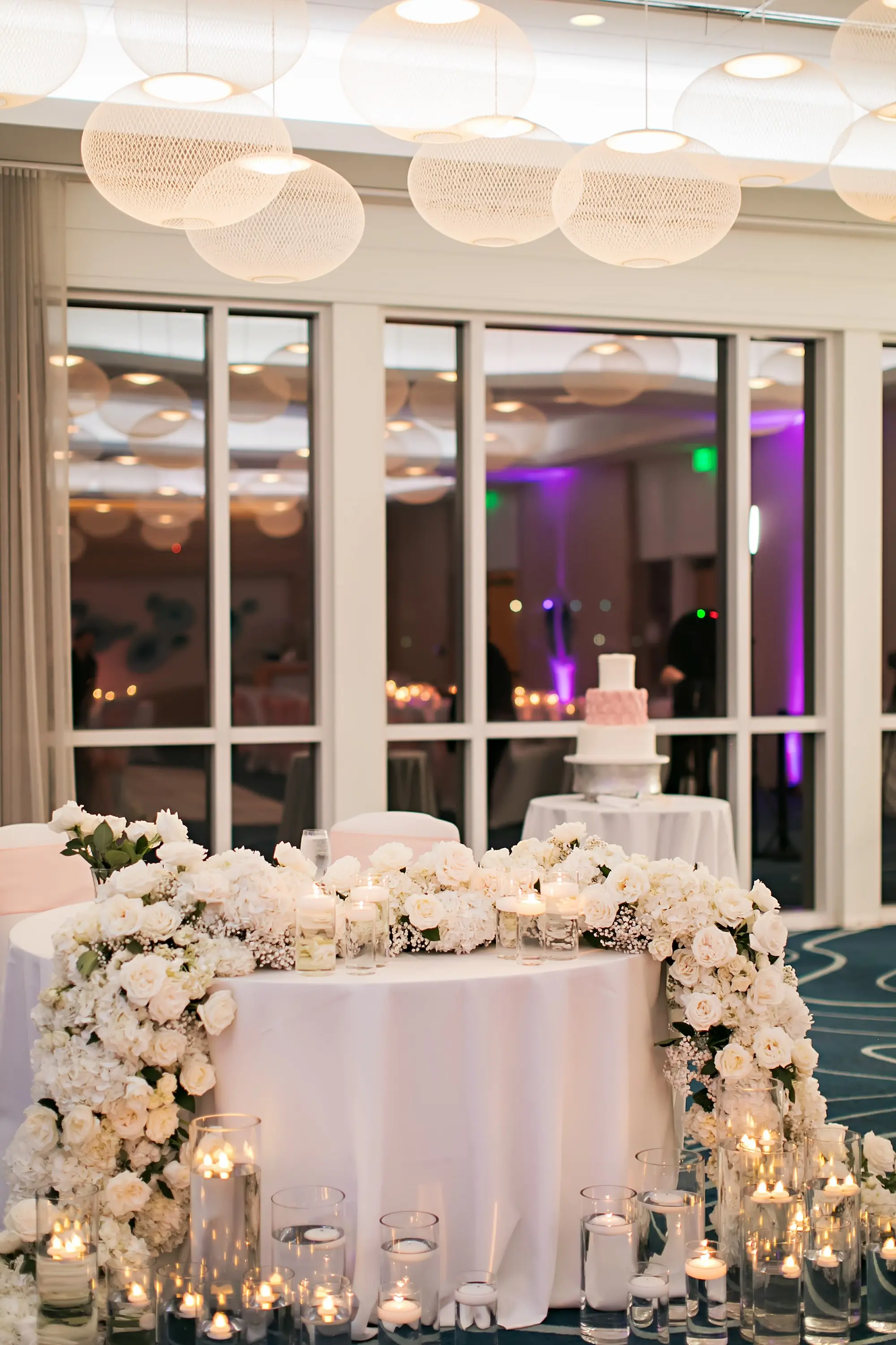 Romantic White Monochromatic Sweetheart Table Decor Ideas | Cascading White Flowers and Floating Candles | Sarasota Florist Beneva Flowers | Event Venue Lido Beach Resort