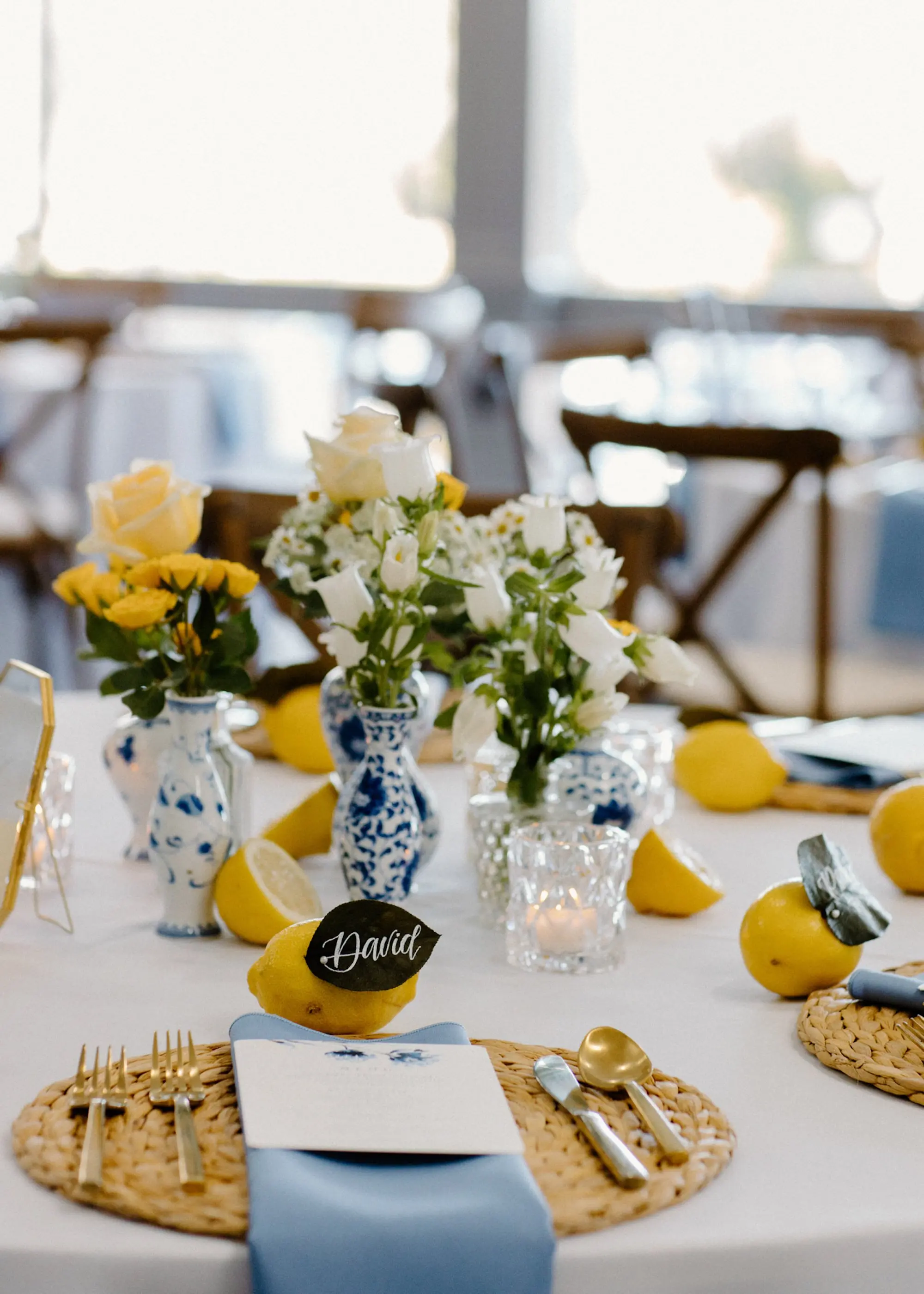 White Linen with Woven Chargers and Romantic Tea Candle Wedding Reception Decor Inspiration | Lemon Citrus Garden Theme Wedding Reception Decor Ideas | Bud Vase with White and Yellow Rose Single Stem Centerpieces Inspiration | Tampa Bay Over The Top Linen Rentals | Tampa Bay Planner Unique Weddings and Events