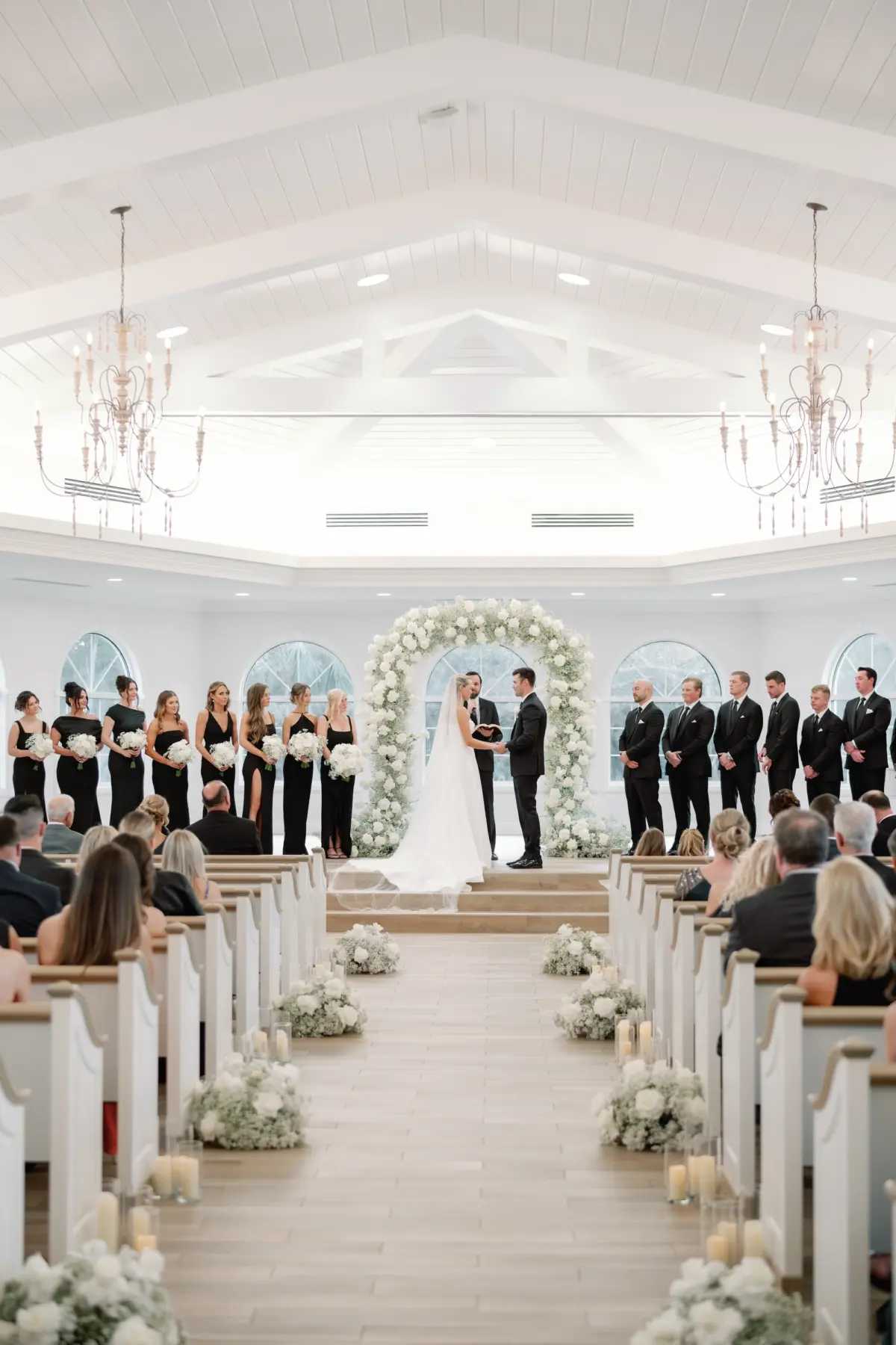 Bride and Groom Wedding Ceremony Vow Exchange Wedding Portrait | Traditional Church Wedding Ceremony Decor Ideas | Classic White Roses and Baby's Breath Aisle Arrangement Decor and Altar Arch Inspiration | Ceremony Venue Harborside Chapel