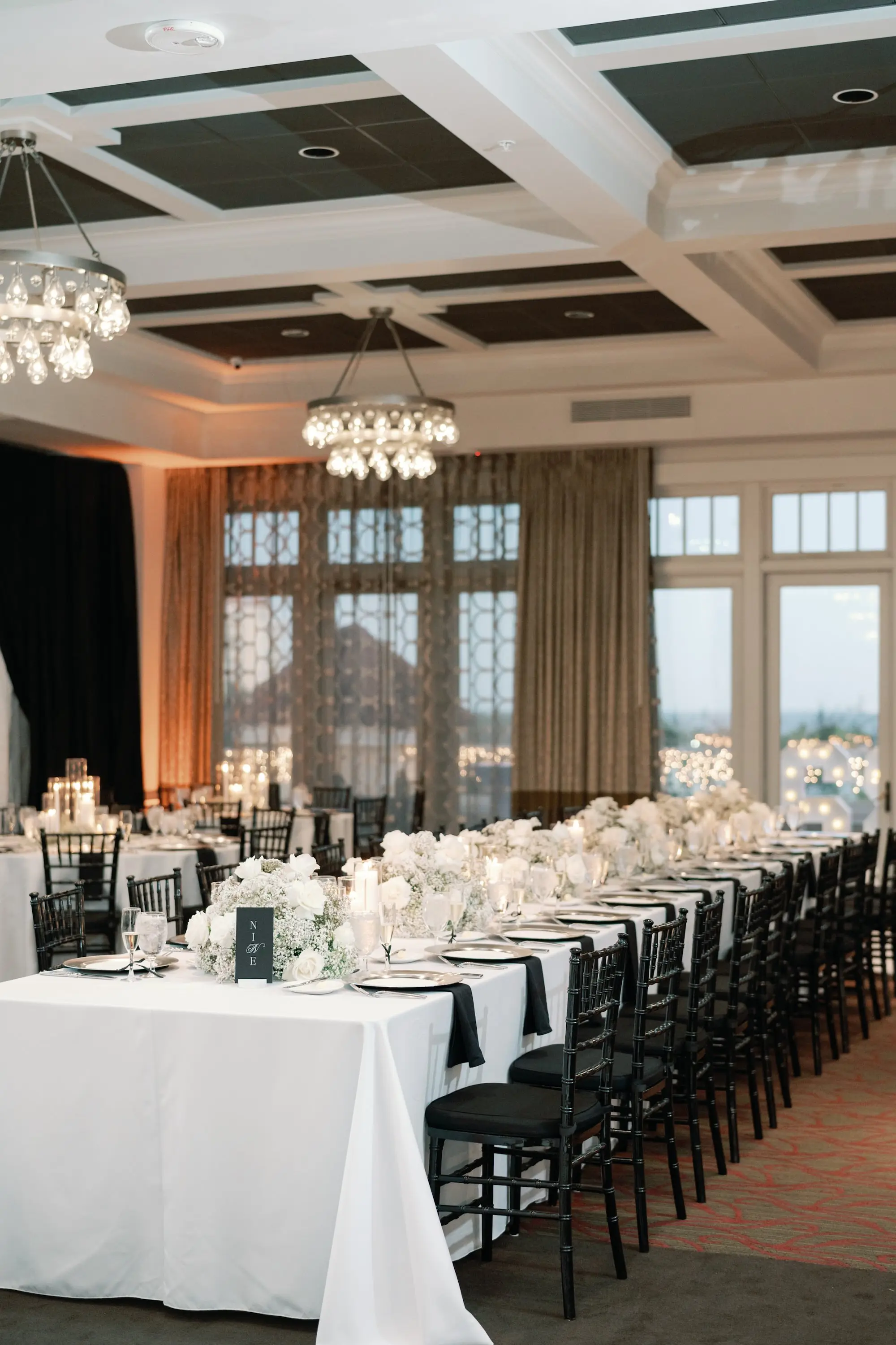 Glamorous Black and White Wedding Reception Ballroom Decor Inspiration | White Linens on Long Tables with Black Chiavari Chairs Decor Ideas | White Roses and Baby's Breath Centerpiece Arrangement Inspiration | Downtown St. Pete Boutique Hotel Wedding Venue The Birchwood