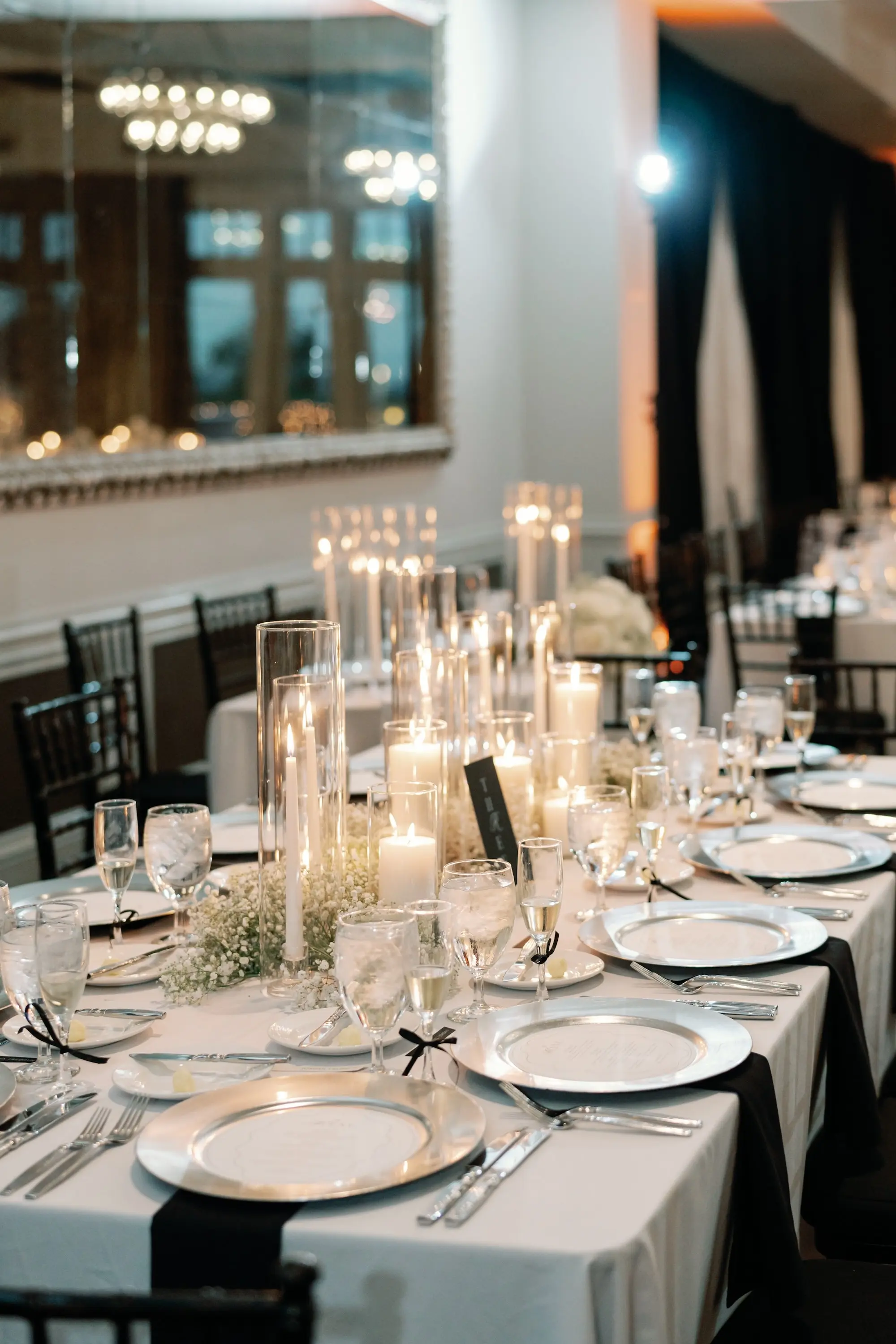 Glamorous Black and White Wedding Reception Ballroom Decor Inspiration | White Linens on Long Tables with Black Chiavari Chairs Decor Ideas | White Baby's Breath and Romantic Candles Centerpiece Arrangement Inspiration | Downtown St. Pete Boutique Hotel Wedding Venue The Birchwood