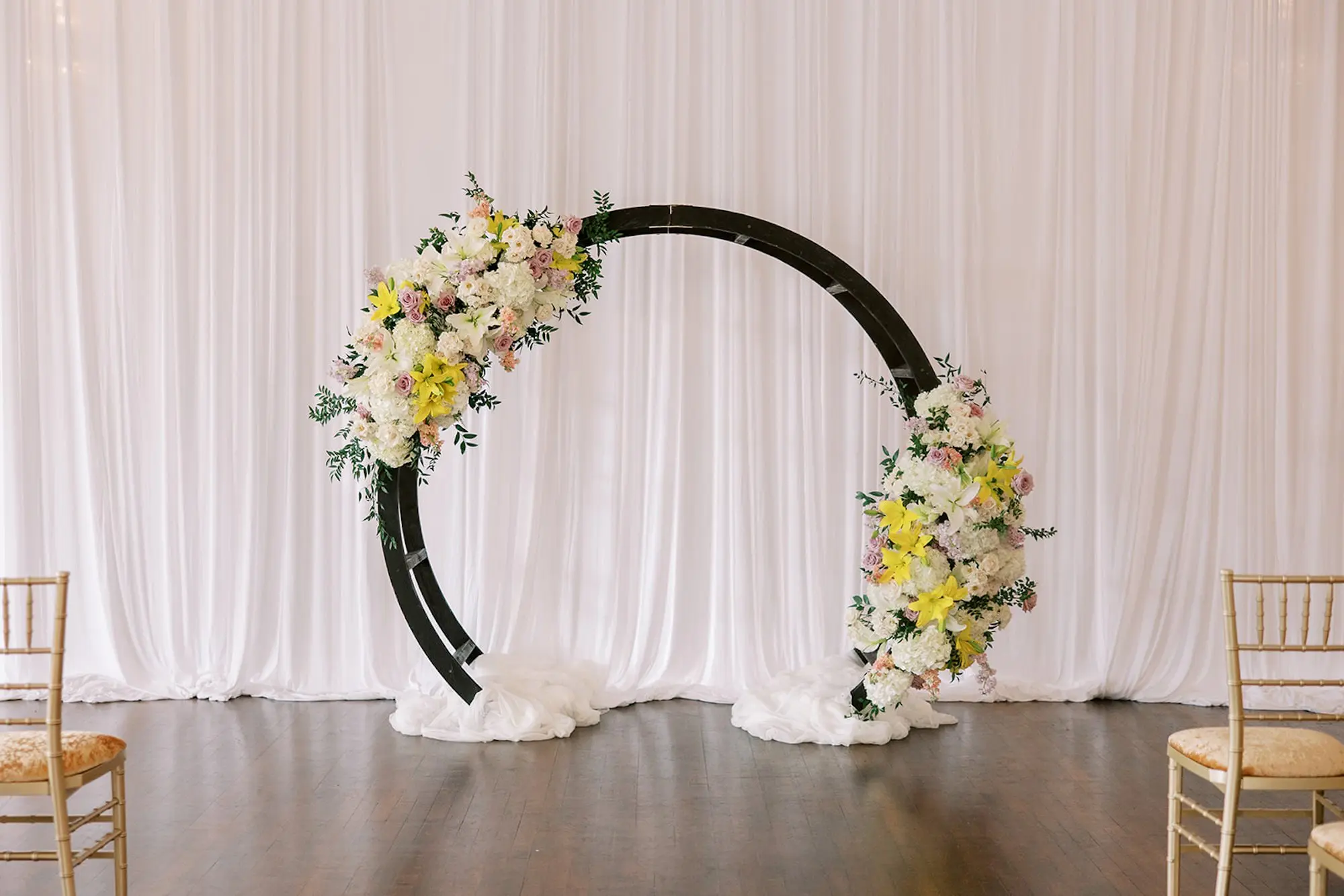 Black Wooden Semi-Circle with White, Cream, Blush, Peach, Yellow, Lavender Pastel Florals Roses, Lilies, Peonies Arrangement Wedding Ceremony Altar Decor Inspiration