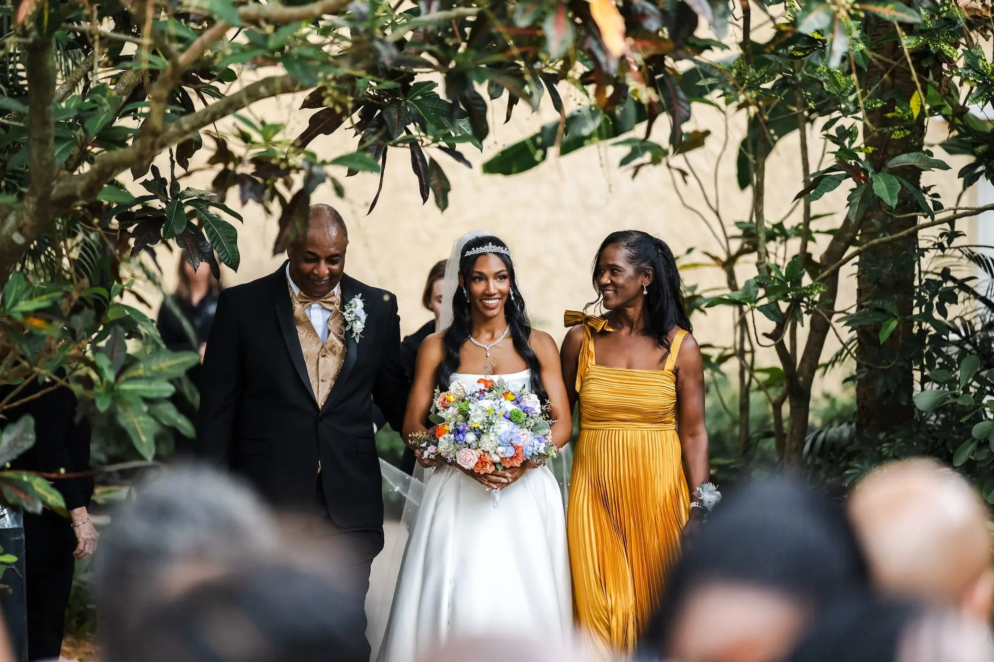 Bride with Father and Mother Walking Down Wedding Aisle
