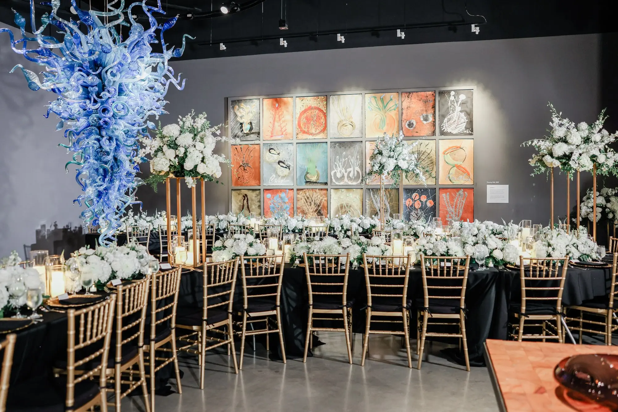 25Classic White Chic St Pete Museum Wedding Inspiration Venue Chihuly Collection - “Best Of” 2025: Wedding Receptions Part 2 Luxurious Ballroom Wedding Reception | Gold Chiavari Chairs | Tall Gold Centerpieces with White Hydrangeas, Roses and Orchid Flower Arrangement Ideas | St Pete Elite Events Catering | Venue The Chihuly Collection at the Morean Arts Center | Tampa Bay Planner Coastal Coordinating