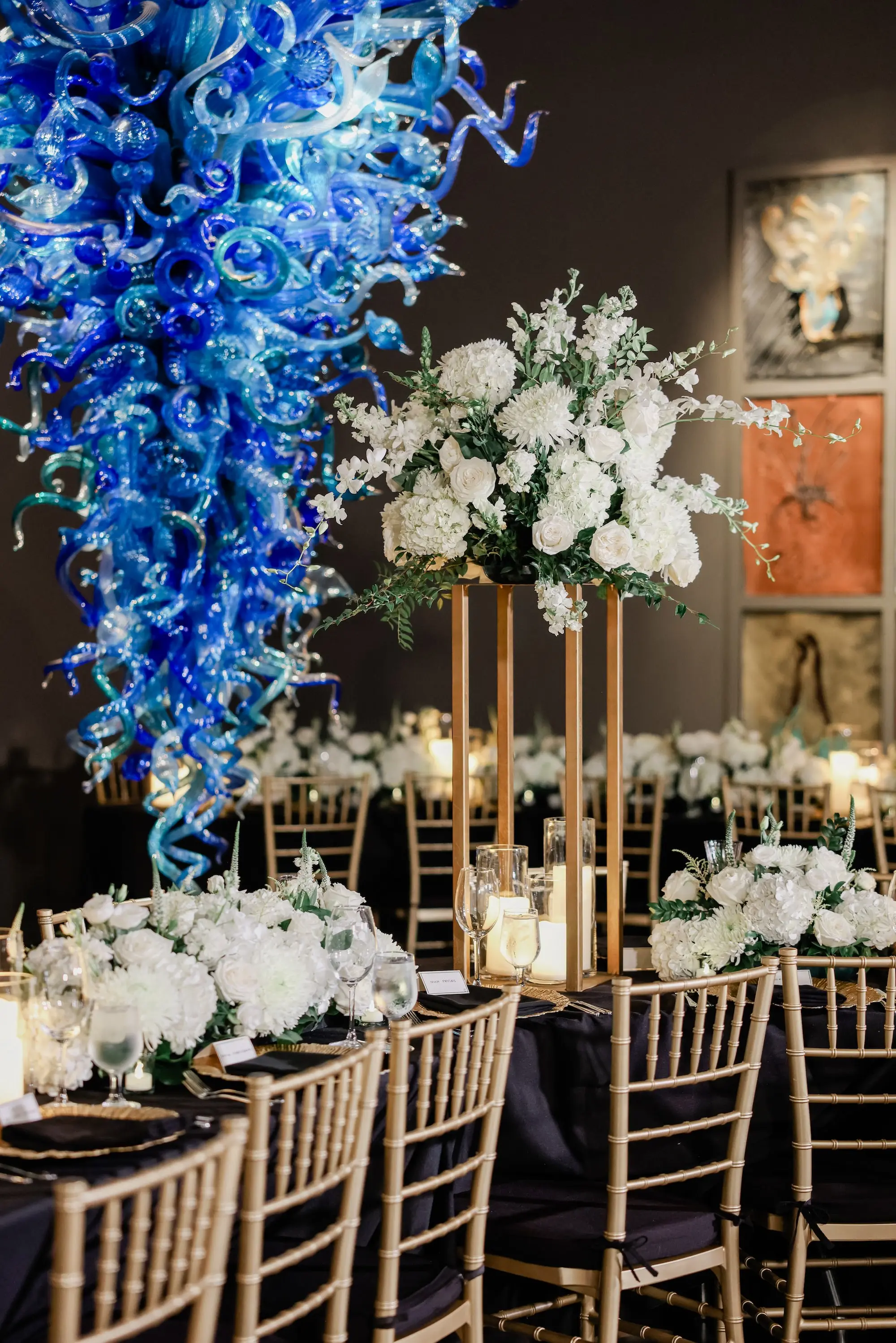 26Classic White Chic St Pete Museum Wedding Inspiration - “Best Of” 2025: Wedding Receptions Part 2 Intimate Elegant Chic Ballroom Wedding Reception | Gold Chiavari Chairs | Tall Gold Centerpieces with White Hydrangeas, Roses and Orchid Flower Arrangement Ideas | St Pete Elite Events Catering | Venue The Chihuly Collection at the Morean Arts Center | Tampa Bay Planner Coastal Coordinating