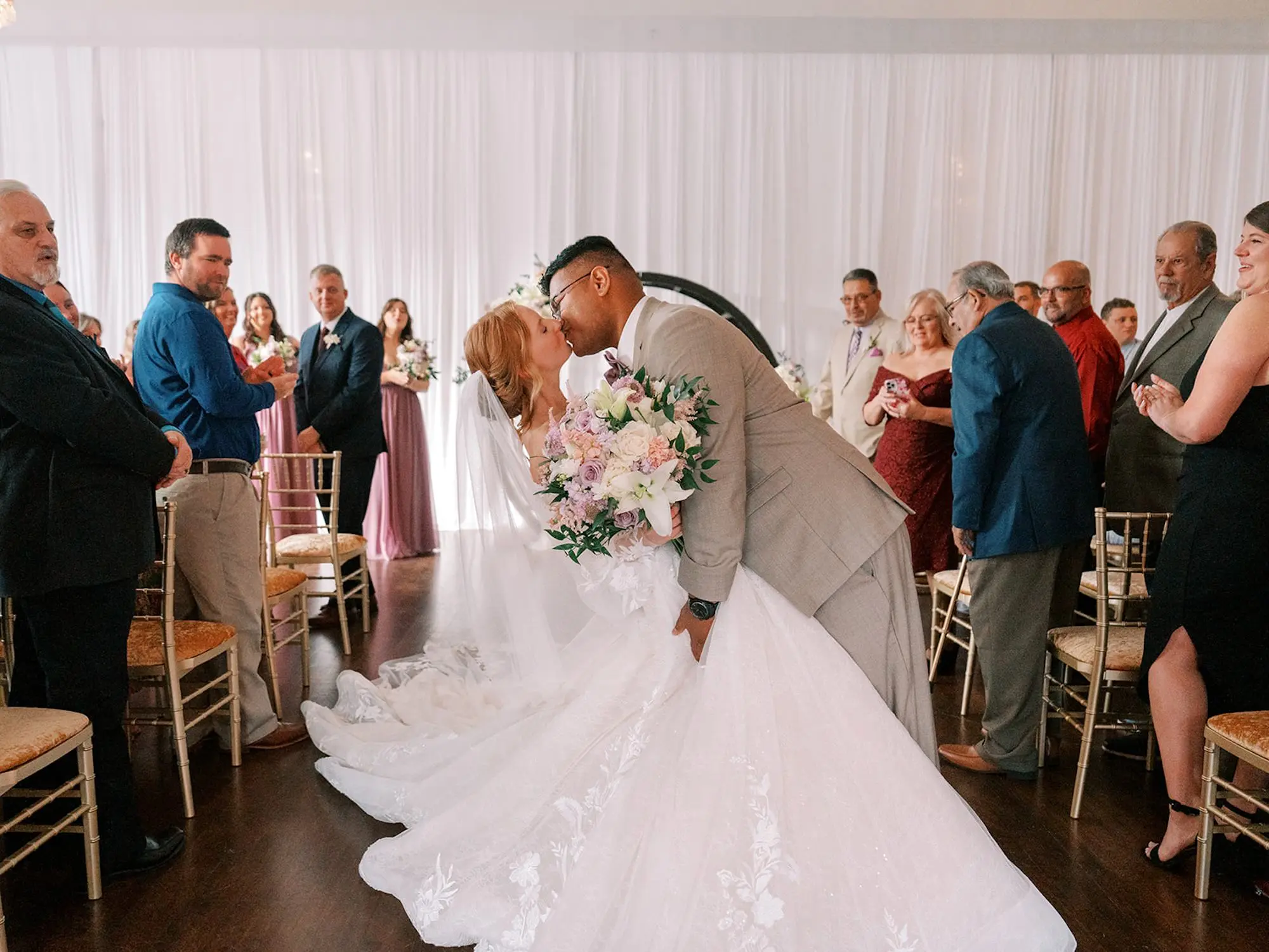 Bride and Groom Kissing Ceremony Aisle Wedding Portrait | Gold Chiavari Chairs with Gold Velvet Seating Ceremony Decor Ideas | Venue The Orlo | South Tampa Photographer Eddy Almaguer Photography