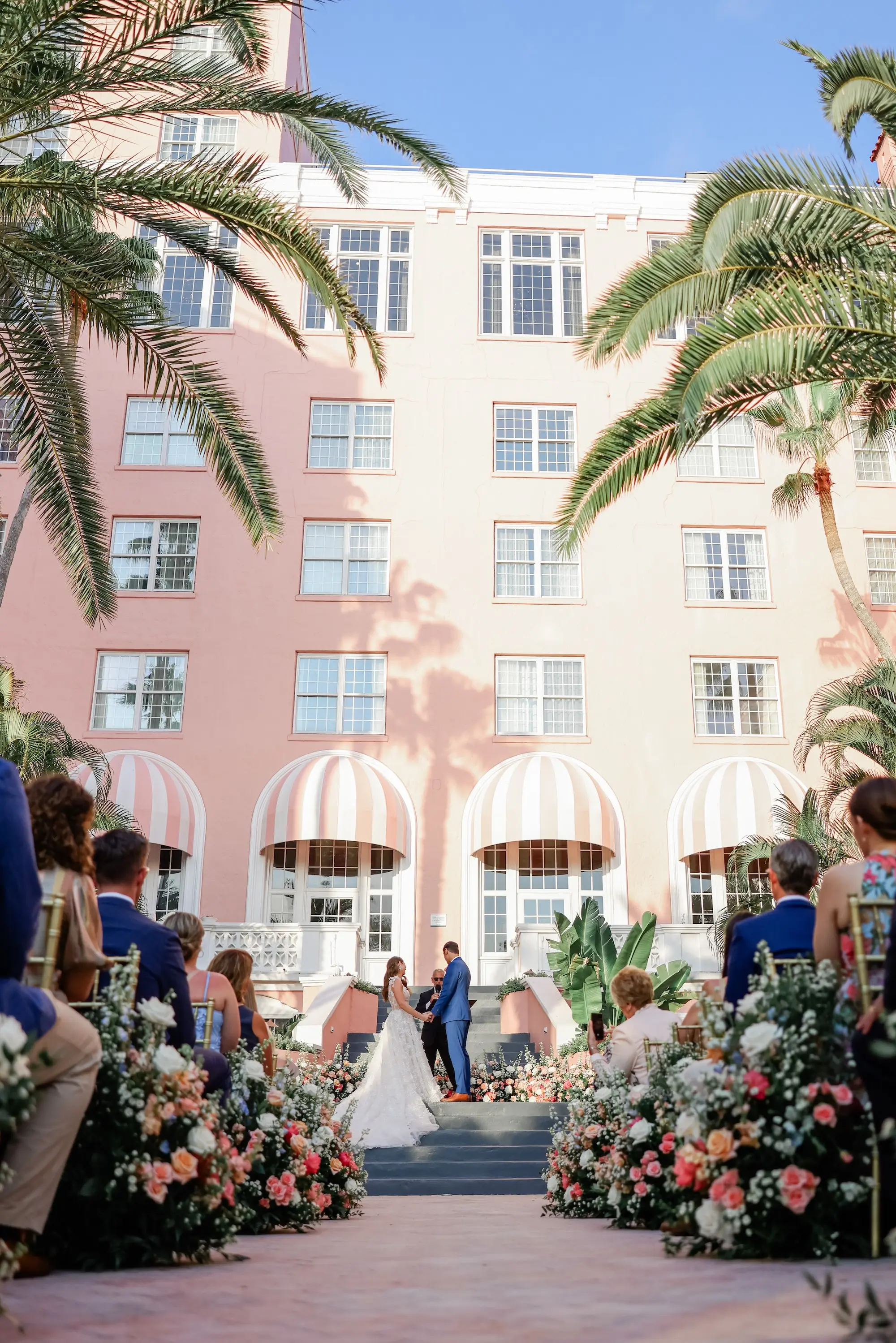 Bride and Groom Wedding Ceremony Vow Exchange Wedding | Pink, White, Coral Roses and Baby's Breath Flower Arrangement Wedding Ceremony Aisle Decor Ideas | Gold Chiavari Chair Rentals by Tampa Bay Kate Ryan Event Rentals | Outdoor Beachfront Resort Wedding Ceremony Venue | St Pete Beach Wedding Venue Don CeSar | Tampa Bay Planner Blue Skies Weddings and Events | St Pete Photographer Lifelong Photography Studio