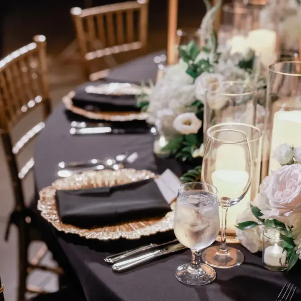 Elegant Ballroom Wedding Reception | Gold Chiavari Chairs | Centerpieces with White Floral Arrangement Ideas | Black Linens with Gold Chargers and Black Napkins Tablescape Decor Inspiration | St Pete Elite Events Catering | Venue The Chihuly Collection at the Morean Arts Center | Tampa Bay Planner Coastal Coordinating