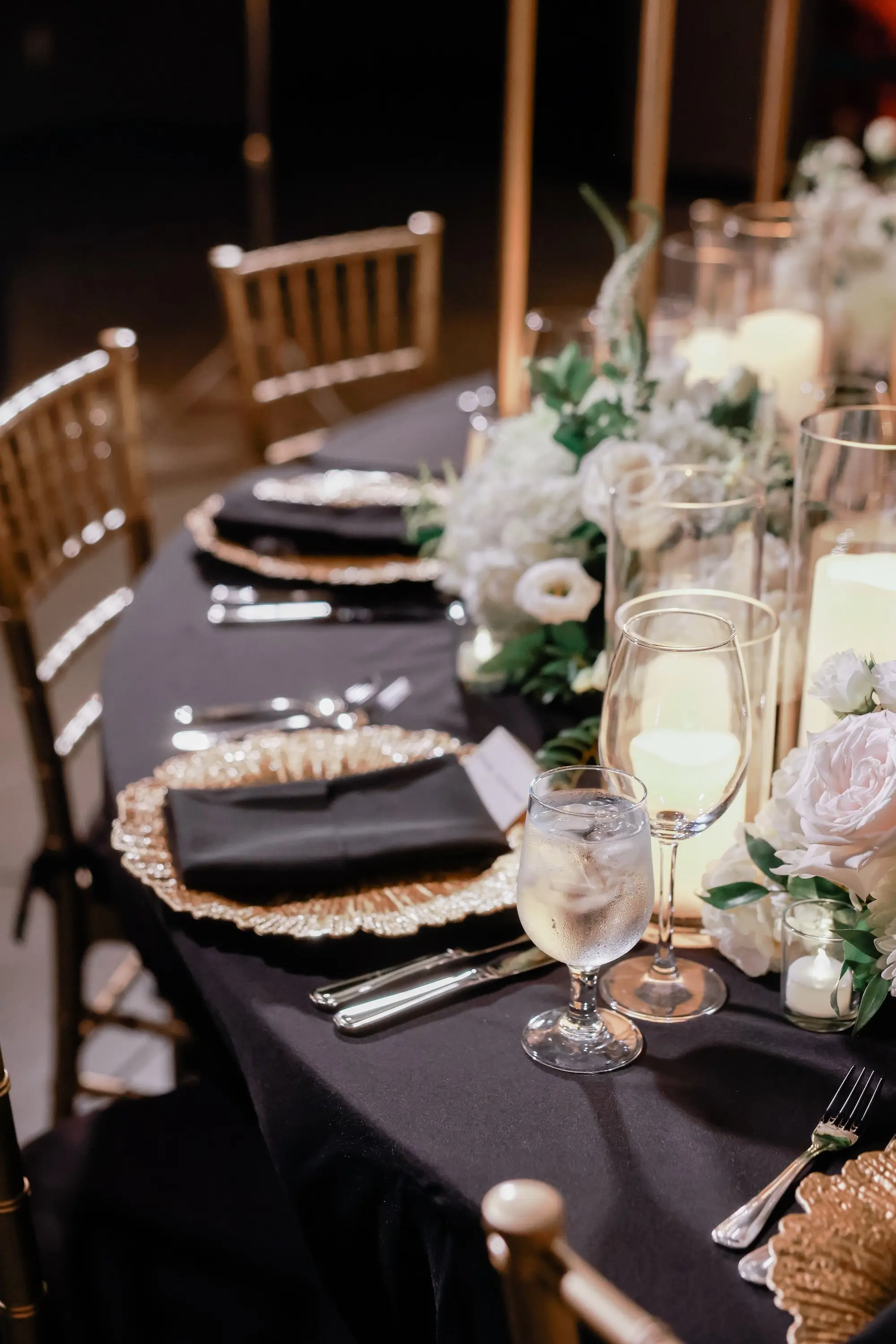 30Classic White Chic St Pete Museum Wedding Inspiration - “Best Of” 2025: Wedding Receptions Part 2 Elegant Ballroom Wedding Reception | Gold Chiavari Chairs | Centerpieces with White Floral Arrangement Ideas | Black Linens with Gold Chargers and Black Napkins Tablescape Decor Inspiration | St Pete Elite Events Catering | Venue The Chihuly Collection at the Morean Arts Center | Tampa Bay Planner Coastal Coordinating