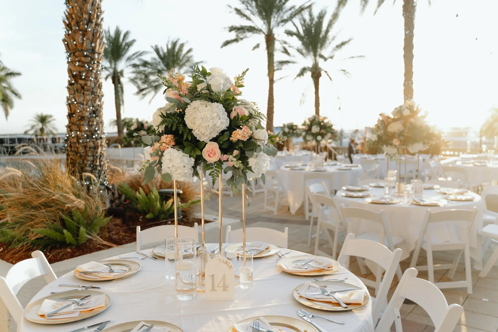 30Romantic Rose Gold and Champagne Wedding Ideas - “Best Of” 2025: Wedding Receptions Part 2 Rose Gold and Champagne Outdoor Waterfront Wedding Reception Decor Inspiration | White Chairs with White Linens and Sting Bistro Lights Decor Ideas | Tall Gold Centerpiece Vases with White Hydrangeas and Blush Pink Roses Flower Arrangement Inspiration | Tampa Bay Florida Waterfront Wedding Venue Westshore Yacht Club