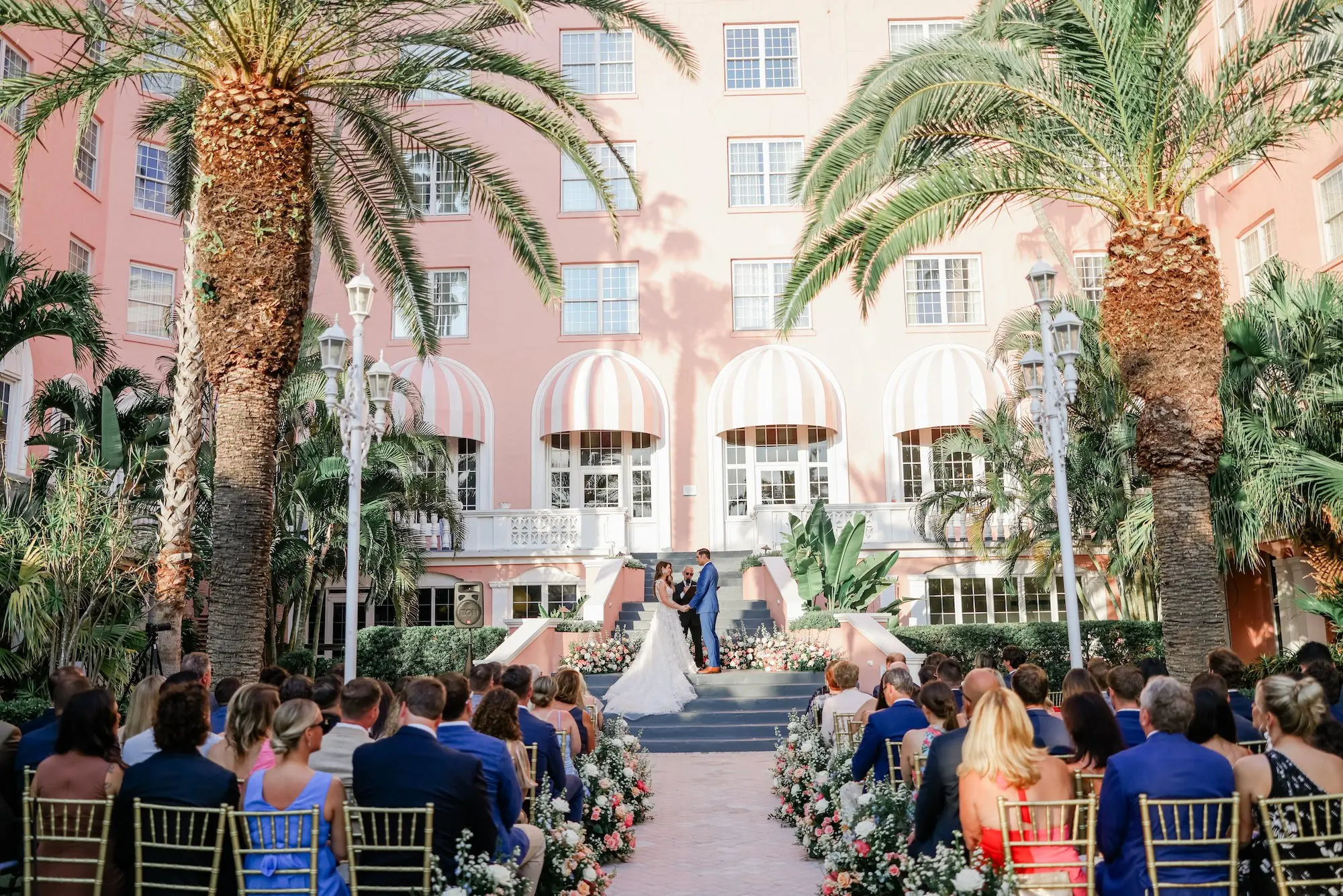 Bride and Groom Wedding Ceremony Vow Exchange Wedding | Pink, White, Coral Roses and Baby's Breath Flower Arrangement Wedding Ceremony Aisle Decor Ideas | Gold Chiavari Chair Rentals by Tampa Bay Kate Ryan Event Rentals | Outdoor Beachfront Resort Wedding Ceremony Venue | St Pete Beach Wedding Venue Don CeSar | Tampa Bay Planner Blue Skies Weddings and Events | St Pete Photographer Lifelong Photography Studio