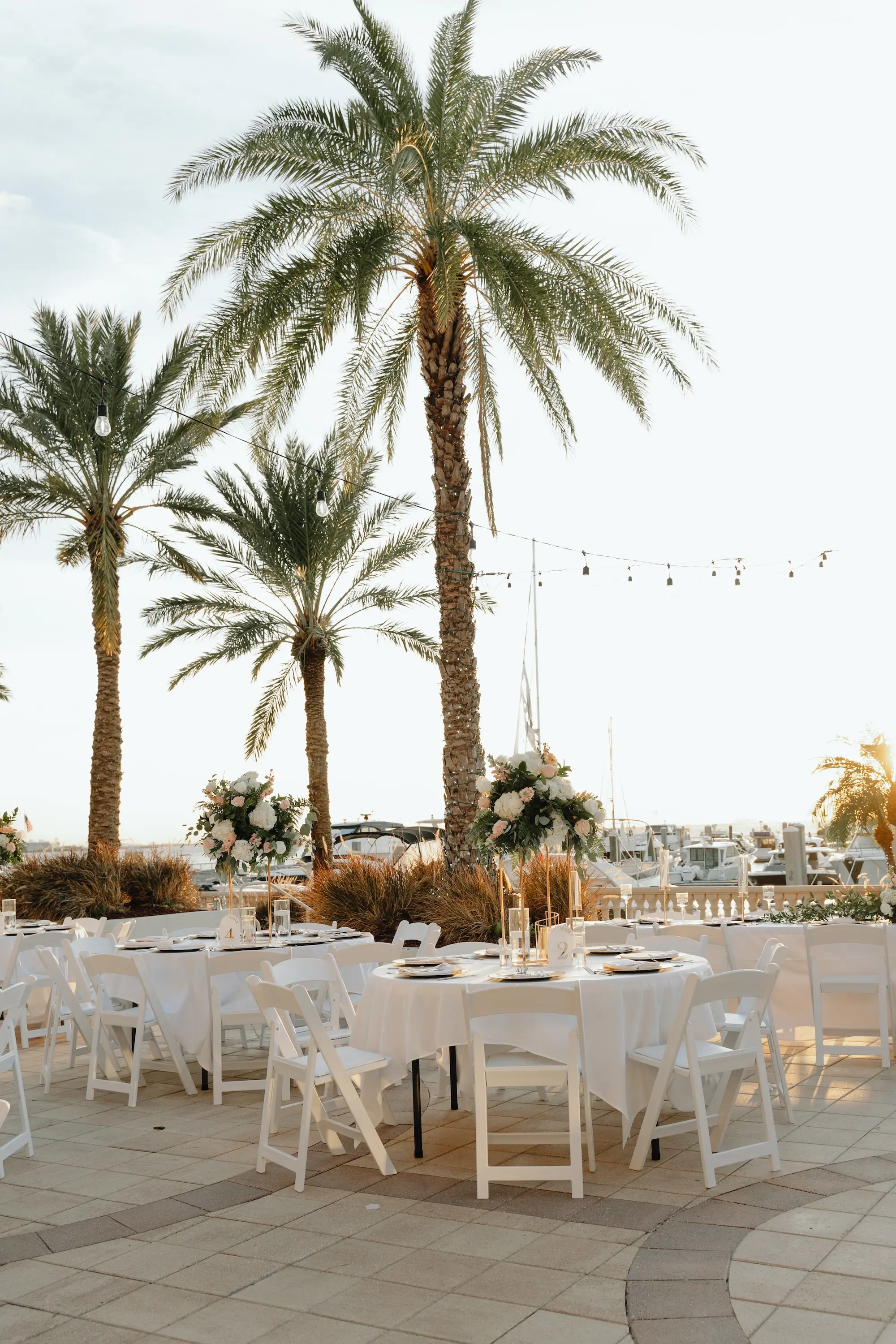34Romantic Rose Gold and Champagne Wedding Ideas - “Best Of” 2025: Wedding Receptions Part 2 Rose Gold and Champagne Outdoor Waterfront Wedding Reception Decor Inspiration | White Chairs with White Linens and Sting Bistro Lights Decor Ideas | Tampa Bay Florida Waterfront Wedding Venue Westshore Yacht Club