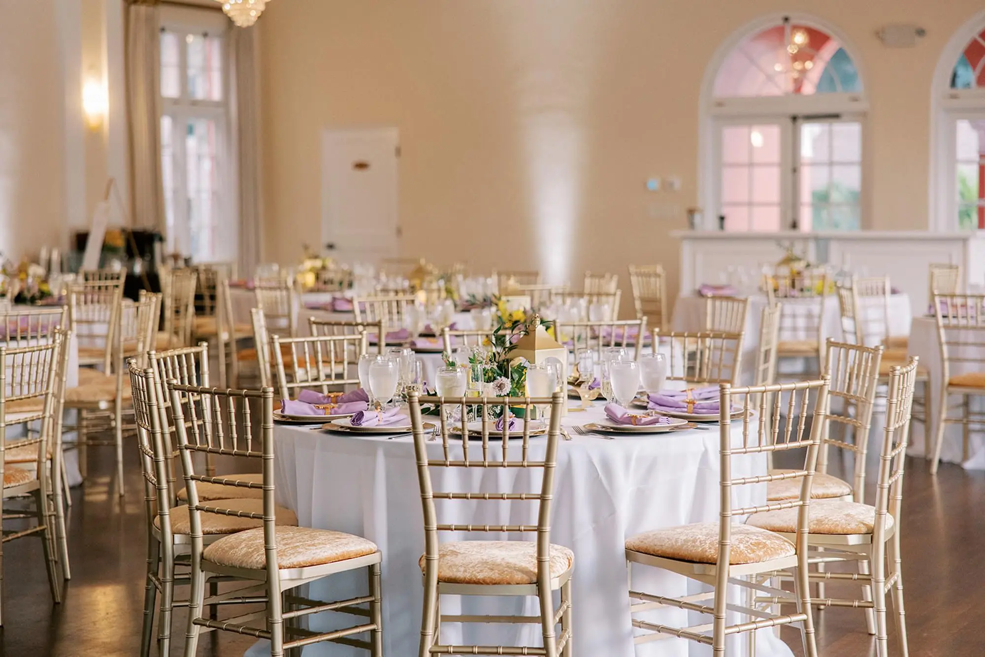 Romantic Ballroom Wedding Reception | Modern Gold Chairs | White Linens and Gold Chiavari Chairs with Gold Velvet Cushions Decor Ideas | Lavender Light Purple Napkins Tablescape Decor Inspiration | Tampa Bay Kate Ryan Event Rentals | Venue The Orlo