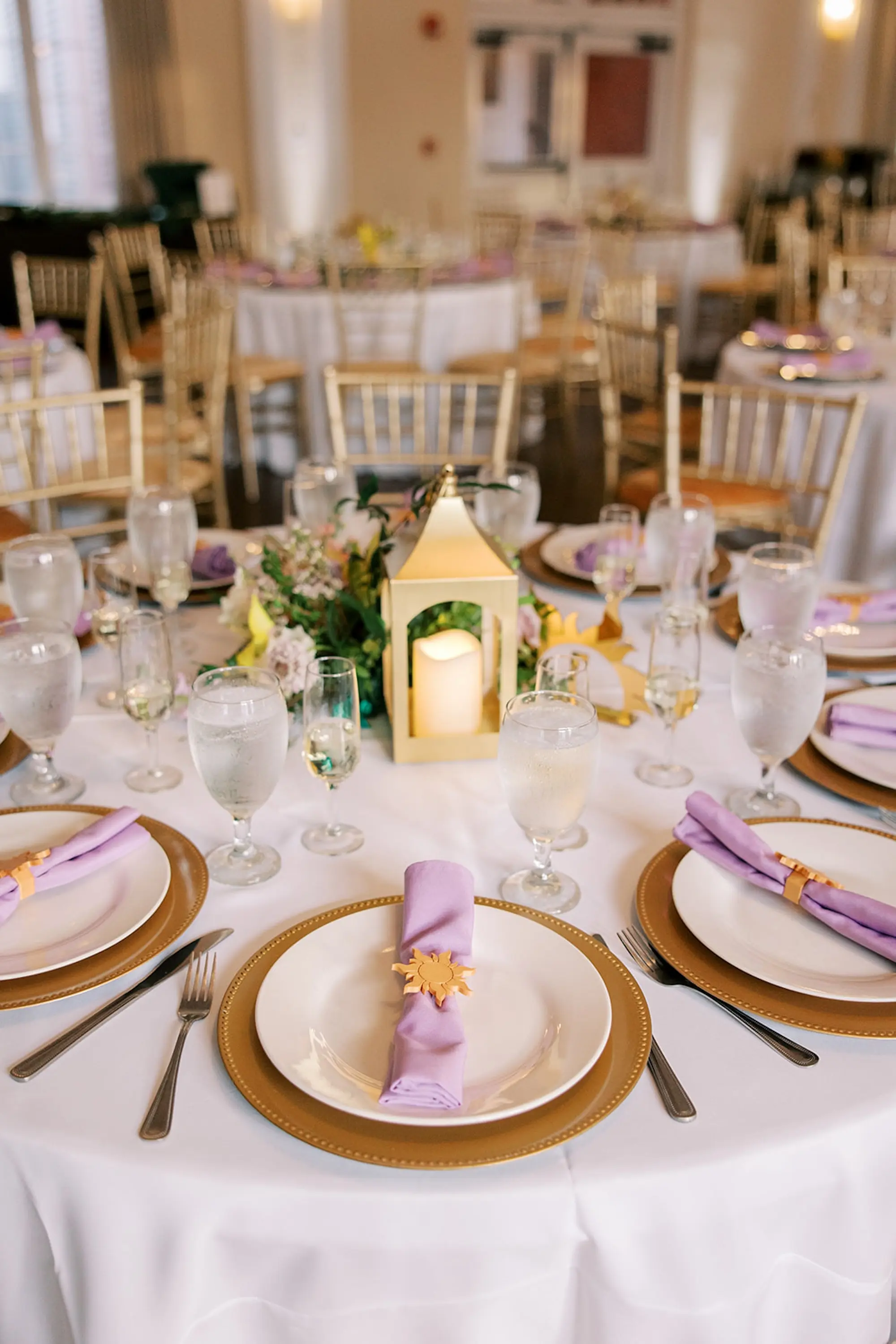Romantic Whimsical Disney Tangled Ballroom Wedding Reception | Gold Chargers with Light Purple Lavender Napkin and Tangled Sun Napkin Holders Inspiration | Lanterns and Floral Centerpieces Wedding Reception Tablescape Decor Ideas | Tampa Bay Kate Ryan Event Rentals