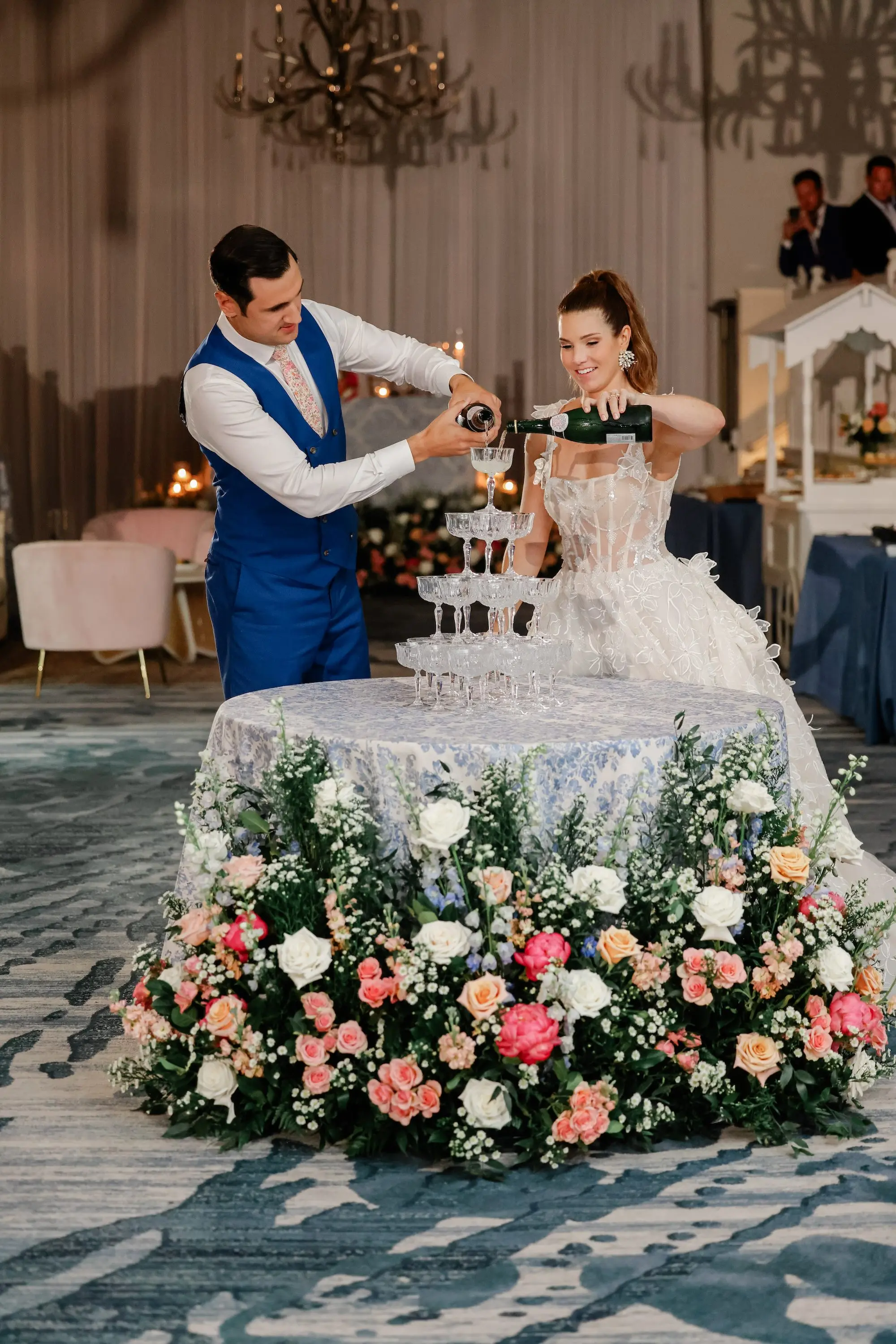 Bride and Groom Pouring Champagne on Champagne Tower Wedding Reception Portrait | White, Pink, Coral, Peach, Blush Roses, Peonies, Carnation and Wisteria Flower Arrangement Reception Decor Inspiration | St Pete Beach Resort Wedding Venue | Tampa Bay Planner Blue Skies Weddings and Events | St Pete Photographer Lifelong Photography Studio