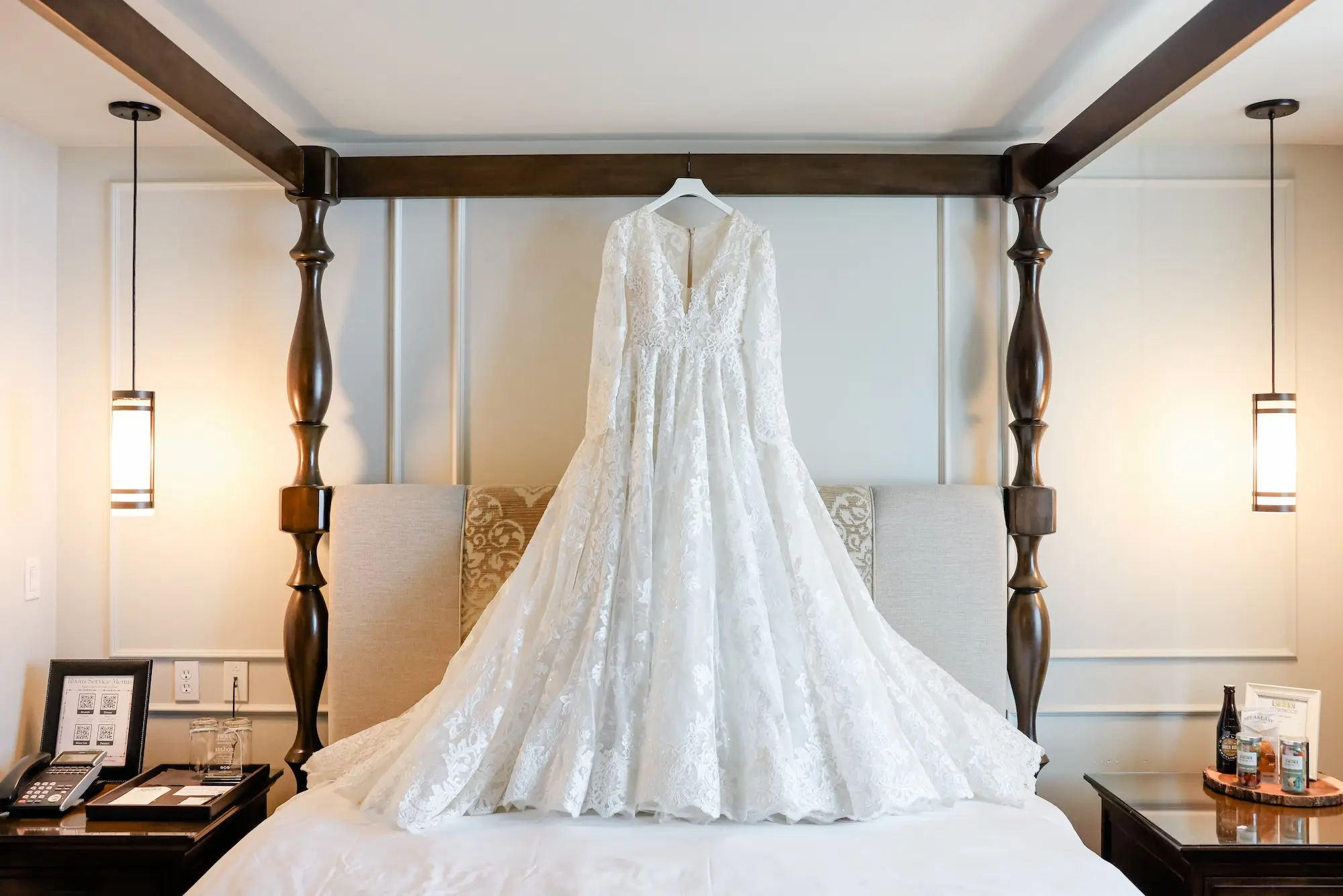 Romantic White, Lace Long-Sleeved Wedding Ballgown with V-Neck hanging from Four Post Bed Inspiration | Downtown St Pete Boutique Hotel The Birchwood | Tampa Bay Wedding Photographer Lifelong Photography Studio