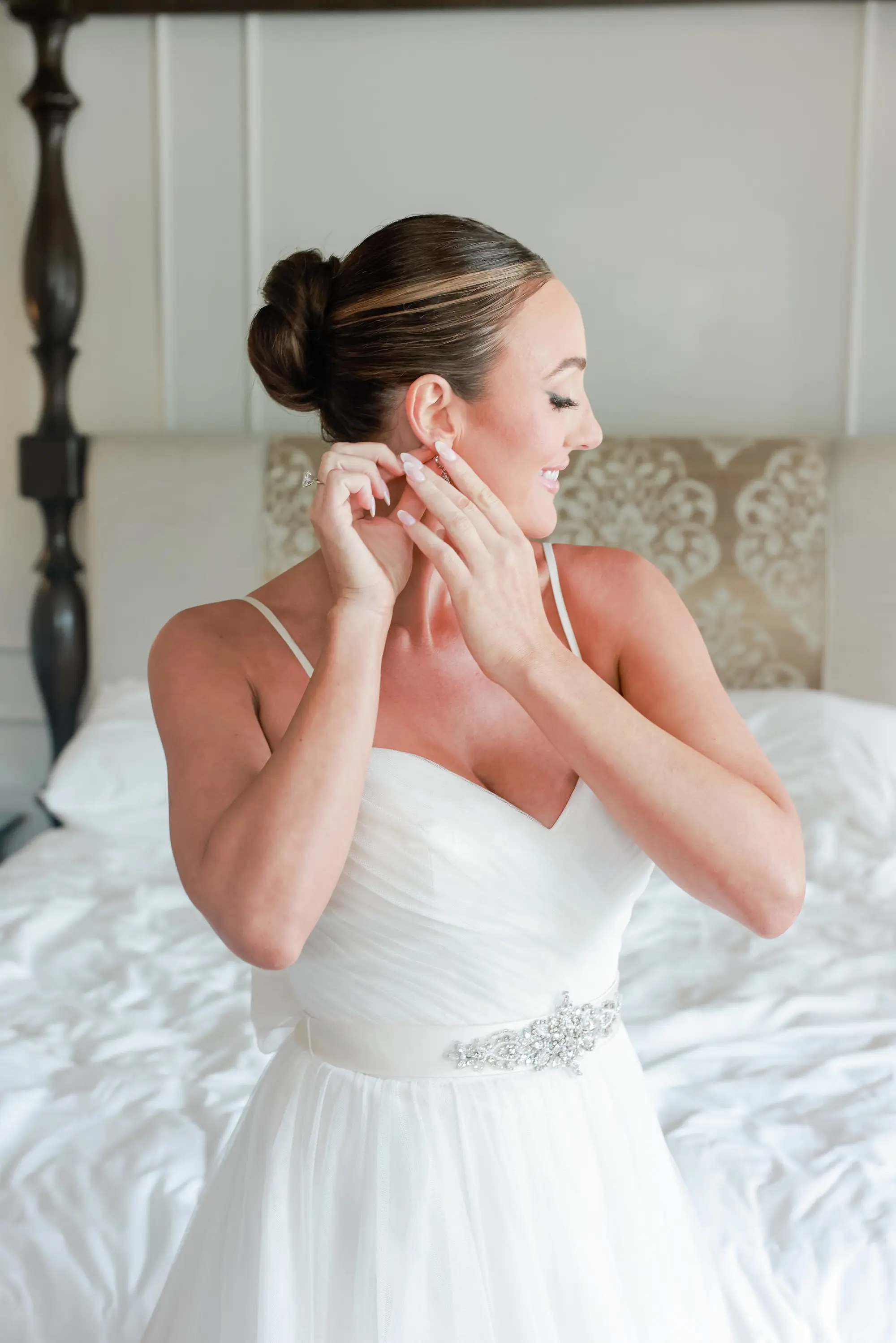 5Elegant Green White and Gold Ballroom Wedding jpg - Tropical Green and White Downtown St. Pete Wedding | The Birchwood Bride Getting Ready Putting Earring On Wedding Portrait | Slick Back Bun Wedding Hair With Pink Hued Makeup and Smokey Eye Ideas | Spaghetti Straps Wedding Dress Sweetheart A-Line Tulle Bridal Wedding Gown with Detailed Beaded Belt Inspiration | Sarasota Hair and Makeup Artist Femme Akoi Beauty Studio | St Pete Photographer Lifelong Photography Studio