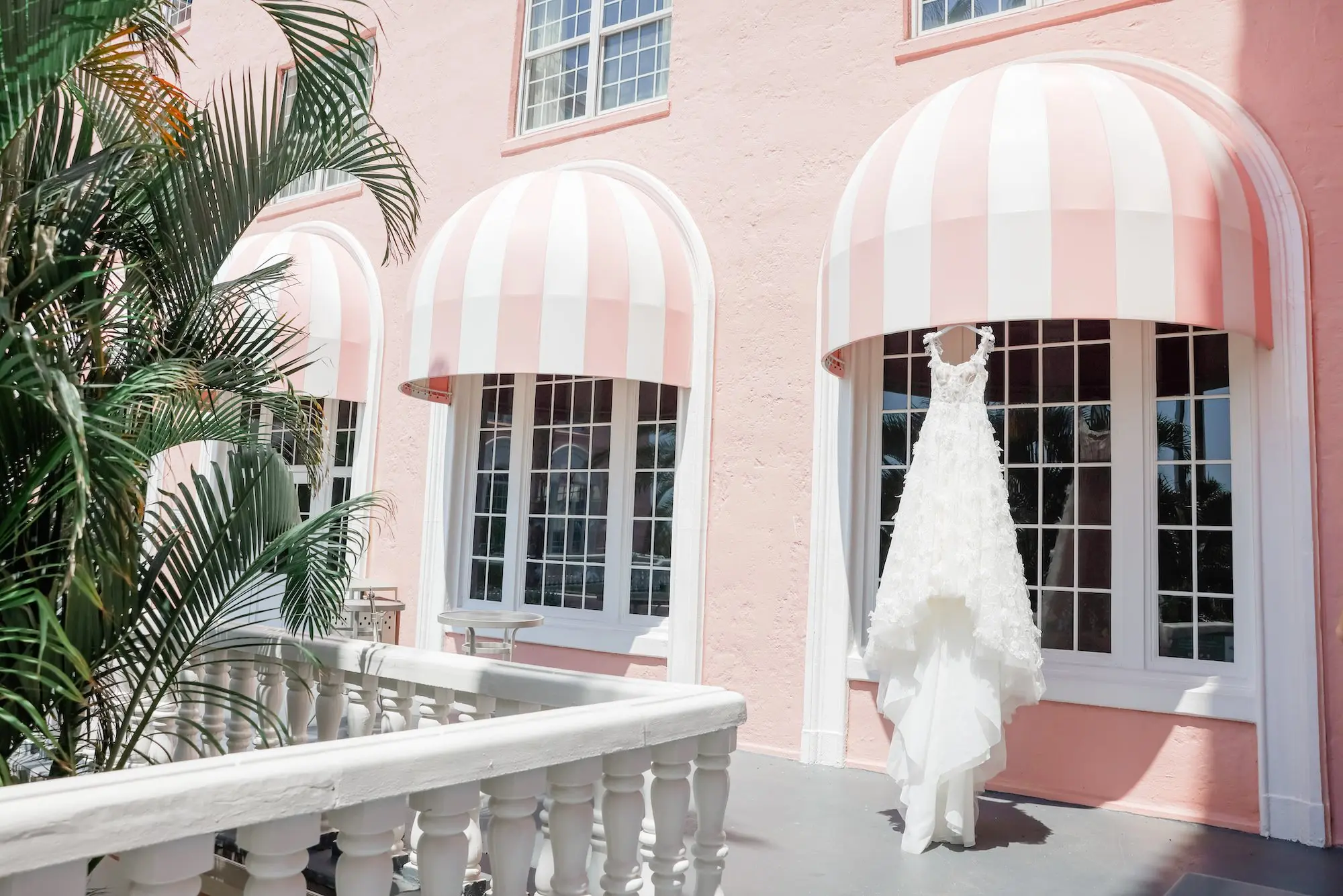 Lace and Tulle Galia Lahav Wedding Gown with Fitted Bodice and Full Layered, Ruffled Skirt and Train Hanging from Pink Awning at St. Pete Beach Don CeSar | St Pete Beach Waterfront Wedding Venue Inspiration