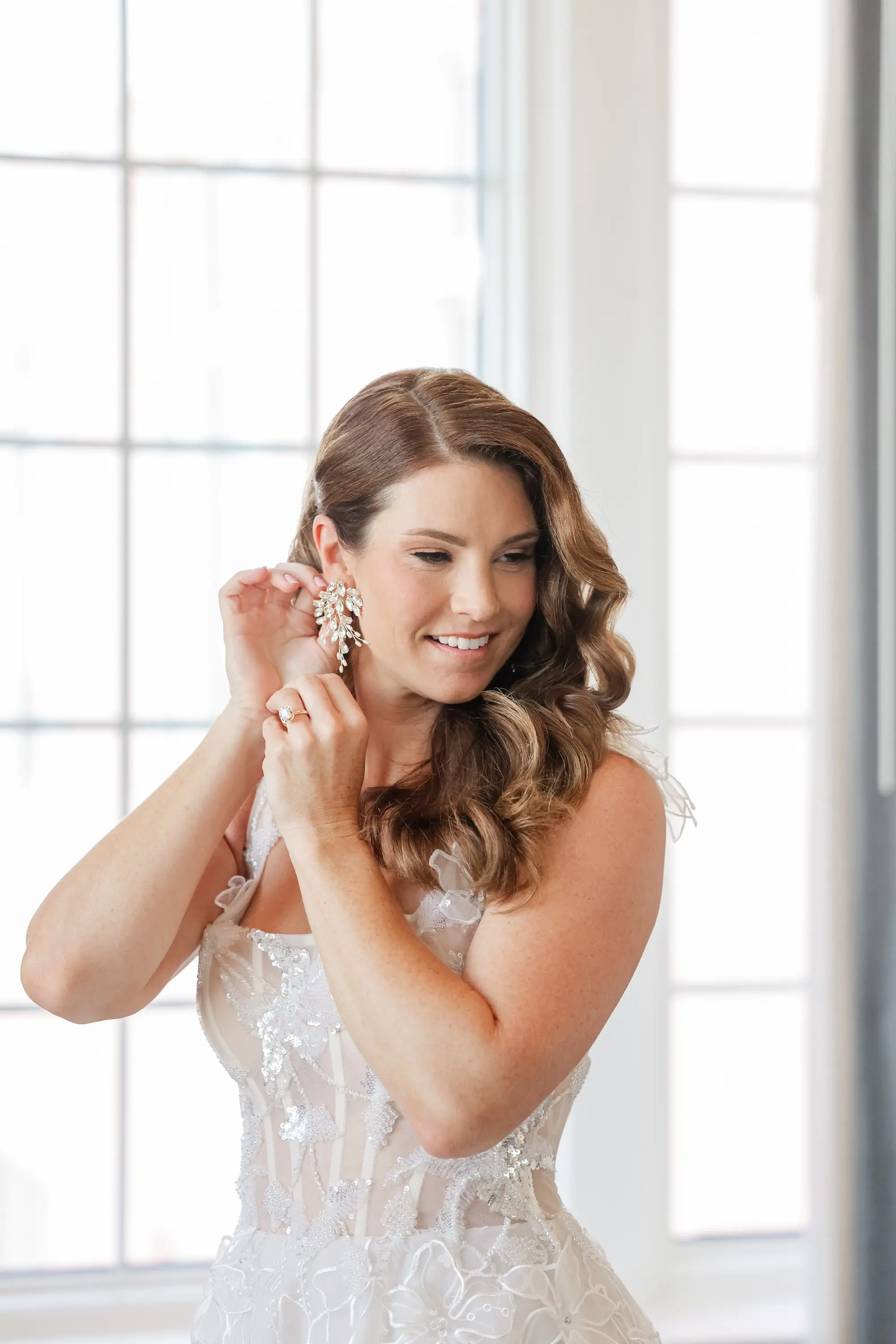 Bride Getting Ready Putting on Diamond Earrings Wedding Portrait | Soft, Romantic Beach Curls Bridal Hair Ideas | Ybor Hair and Makeup Artist Adore Bridal Hair and Makeup | Venue St. Pete Beach Don CeSar | St Pete Photographer Lifelong Photography Studio