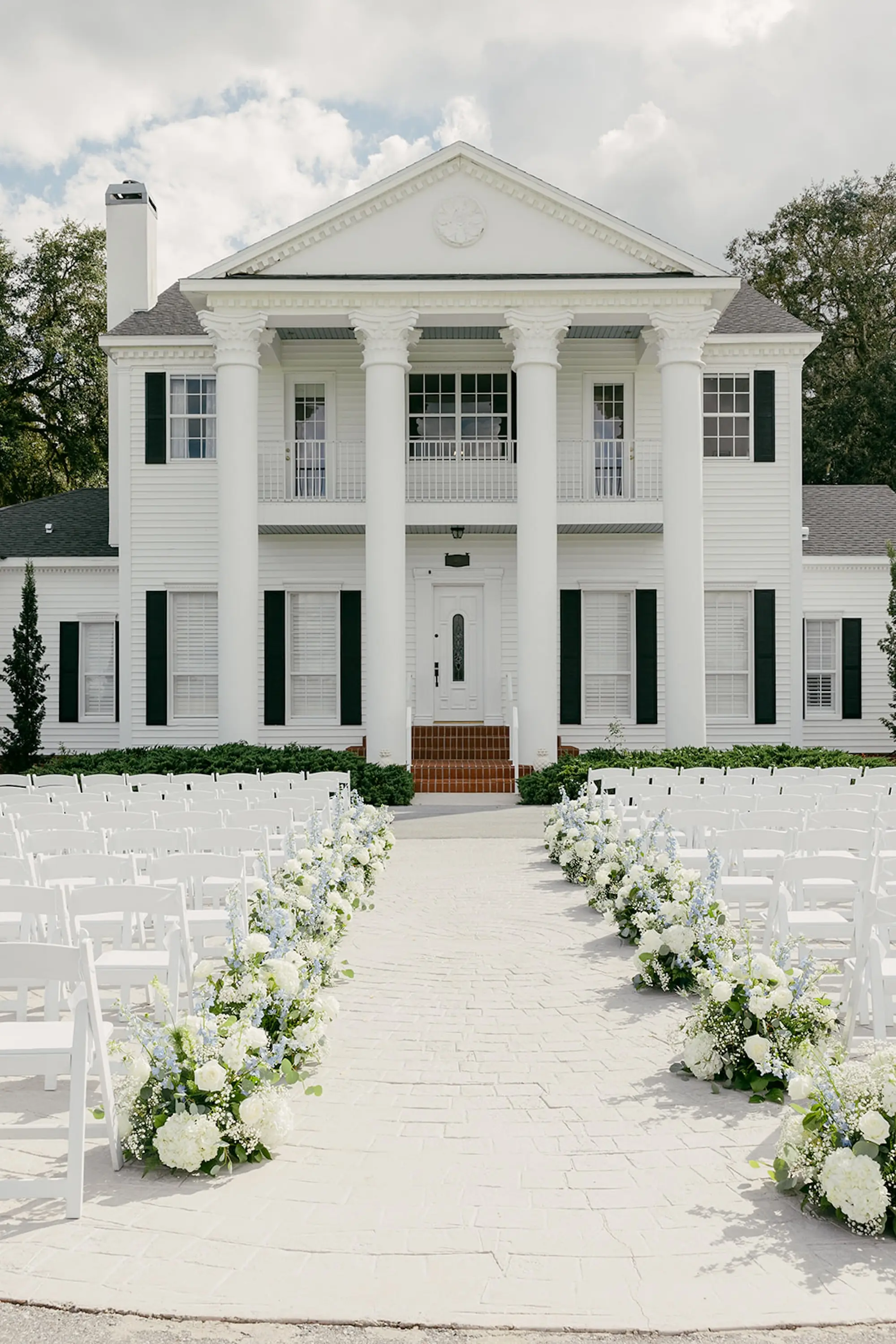 Elegant Outdoor White and Greenery Wedding Ceremony Decor Ideas | White Hydrangeas, Baby's Breath, Light Blue Wisteria and Greenery Flower Arrangement Wedding Ceremony Aisle Decor Inspiration | White Ceremony Chairs Ideas | Tampa Bay Southern Estate Event Venue Legacy Lane Weddings