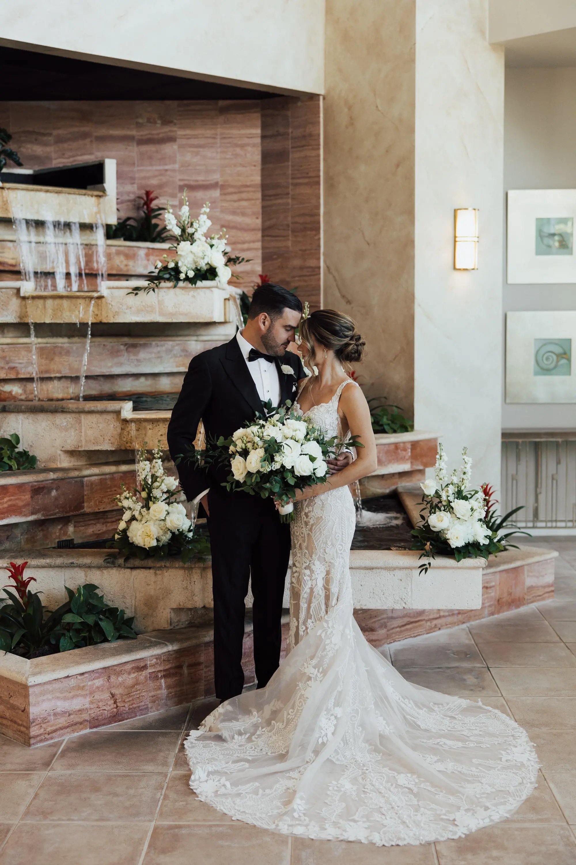 Bride and Groom Wedding Portrait | Lace Applique Mermaid Wedding Gown with Long Train Inspiration | Classic Low Bun with Face Framing Soft Curls Bridal Hair Ideas | Traditional White Roses with Greenery Bridal Wedding Bouquet Inspiration | Classic White and Black Groom's Tuxedo Ideas | Tampa Bay Event Venue Isla Del Sol Yacht and Country Club