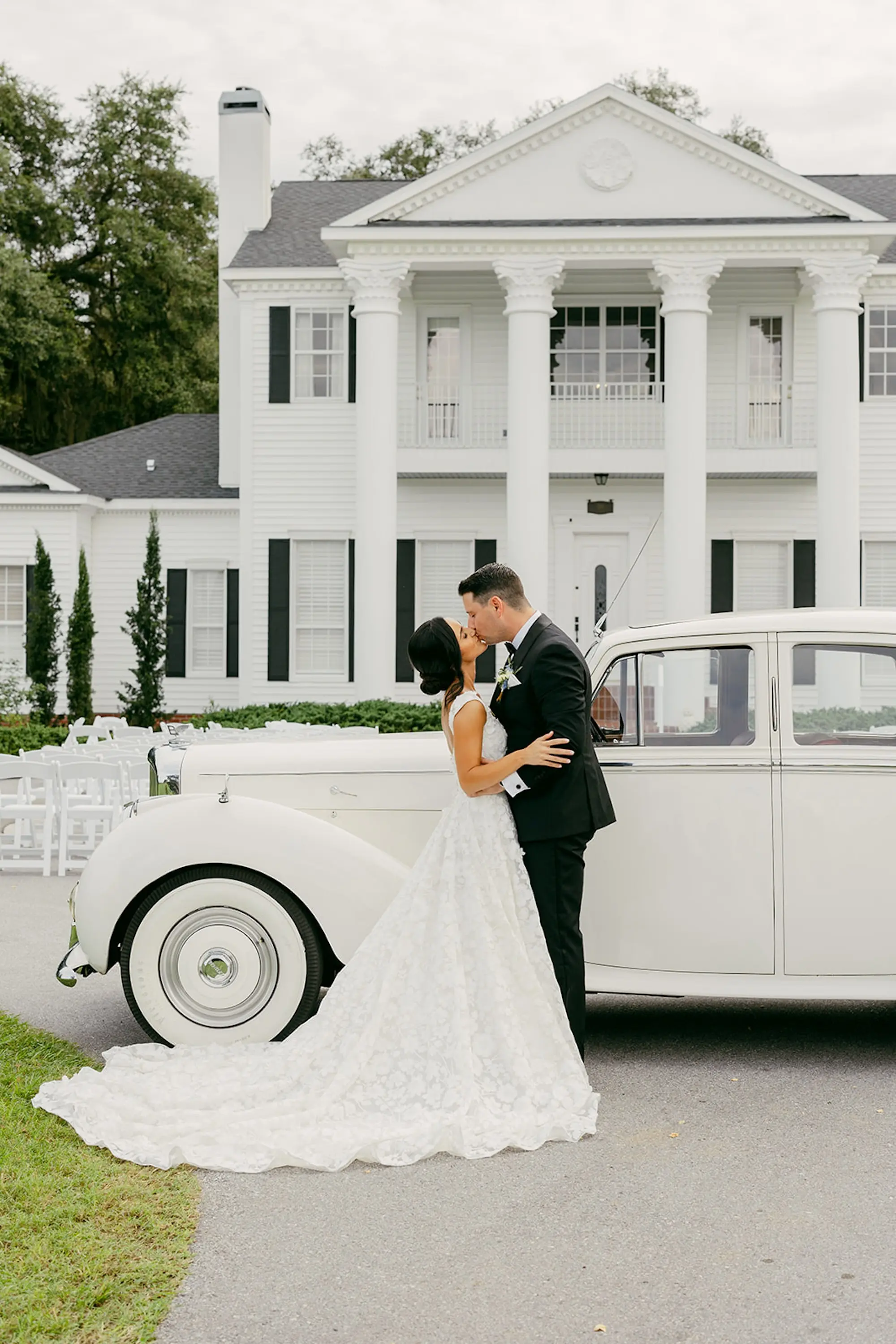 Bride and Groom Vintage White Rolls Royce Car Wedding Portrait | Timeless Low Bun Bridal Hair Inspiration | Ybor Hair and Makeup Artist Adore Bridal Hair and Makeup | Tampa Bay Event Venue Legacy Lane Weddings