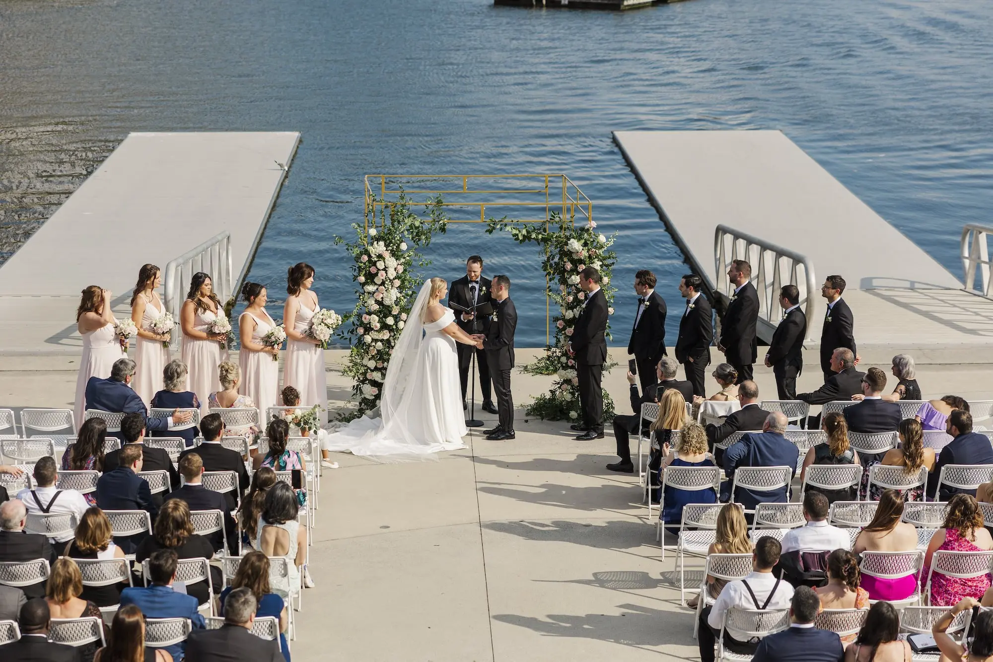 Bride and Groom Outdoor Waterfront Wedding Ceremony Vow Exchange Wedding | Romantic Outdoor Riverfront Wedding Ceremony Inspiration | Gold Chuppah with Light Pink and White Cascading Florals and Greenery Ideas | Tampa Bay Florist Save The Date Florida | Florida Photographer Mary Anna Photography | Venue Tampa River Center