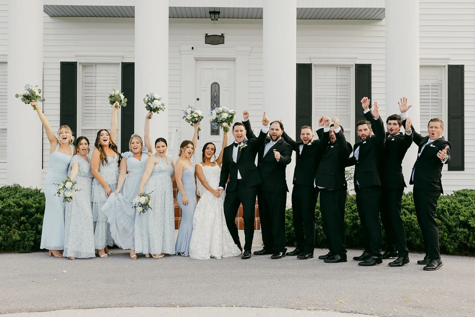 Bride and Groom with Wedding Party Attire Inspiration | Groomsmen in Black Tuxedos Ideas | Mismatched Light Blue Bridesmaids Dress Inspiration
