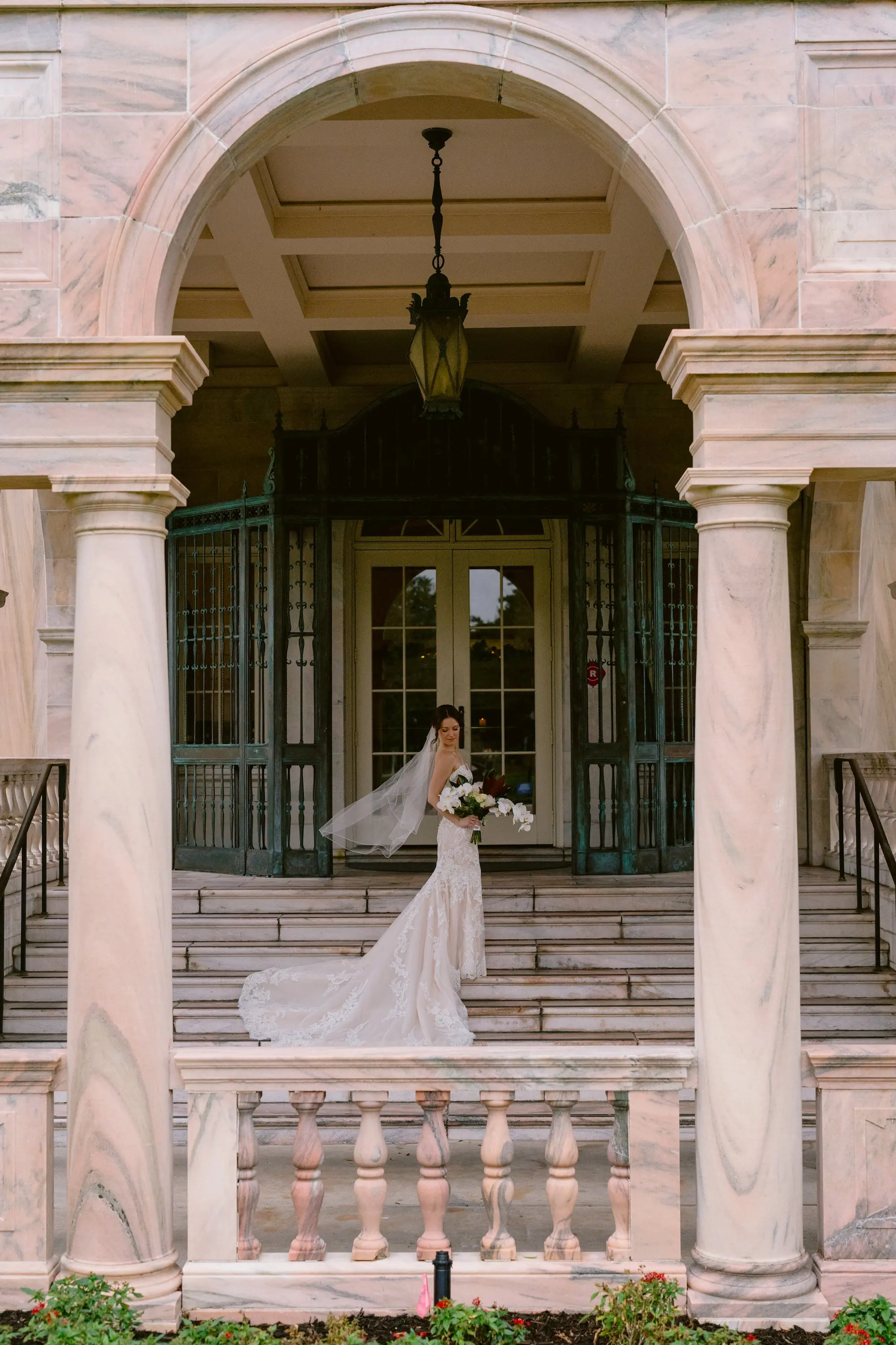 Bridal on Steps of Bride Historic Academic Venue The New College of Florida | Outdoor Fall Wedding Ceremony Inspiration | Lace Detailed Strapless Fit-and-Flare Mermaid Silhouette Maggie Sottero Wedding Gown with Sweetheart Neckline and Chapel-Length Train Ideas | White and Dark Orchid Lilies Bridal Bouquet Inspiration | Tampa Bay Photographer We The Blackwells |