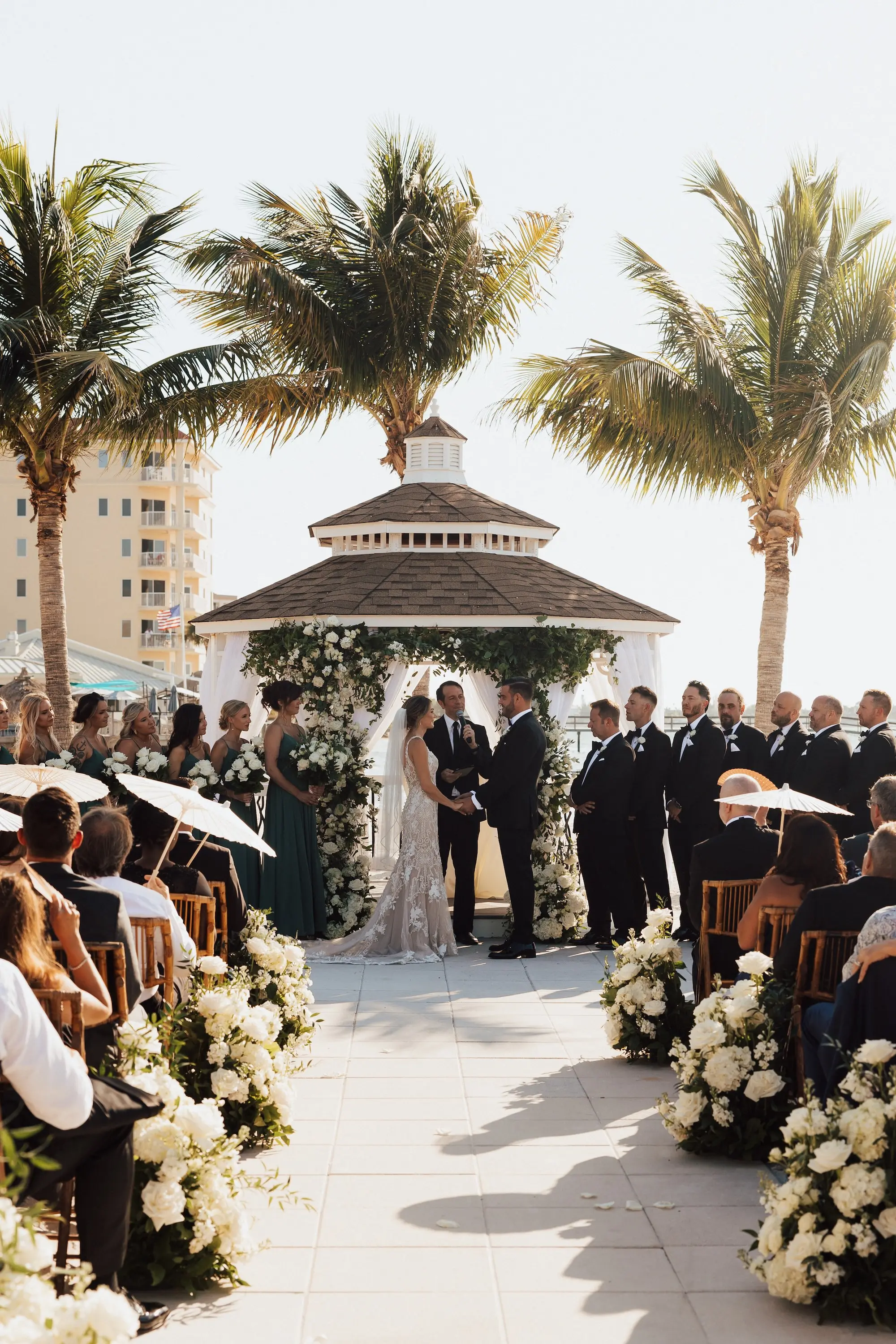 Bride and Groom Outdoor Waterfront Gazebo Wedding Ceremony Vow Exchange Wedding Portrait | Lush White Florals in Greenery Arrangement Ceremony Aisle Decor Ideas | Tampa Bay Event Venue Isla Del Sol Yacht and Country Club