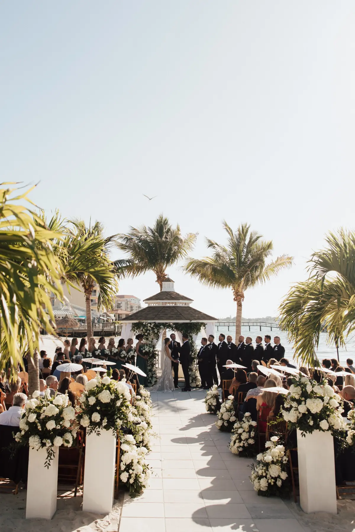 Bride and Groom Outdoor Waterfront Gazebo Wedding Ceremony Vow Exchange Wedding Portrait | Lush White Florals in Greenery Arrangement Ceremony Aisle Decor Ideas | Tampa Bay Event Venue Isla Del Sol Yacht and Country Club